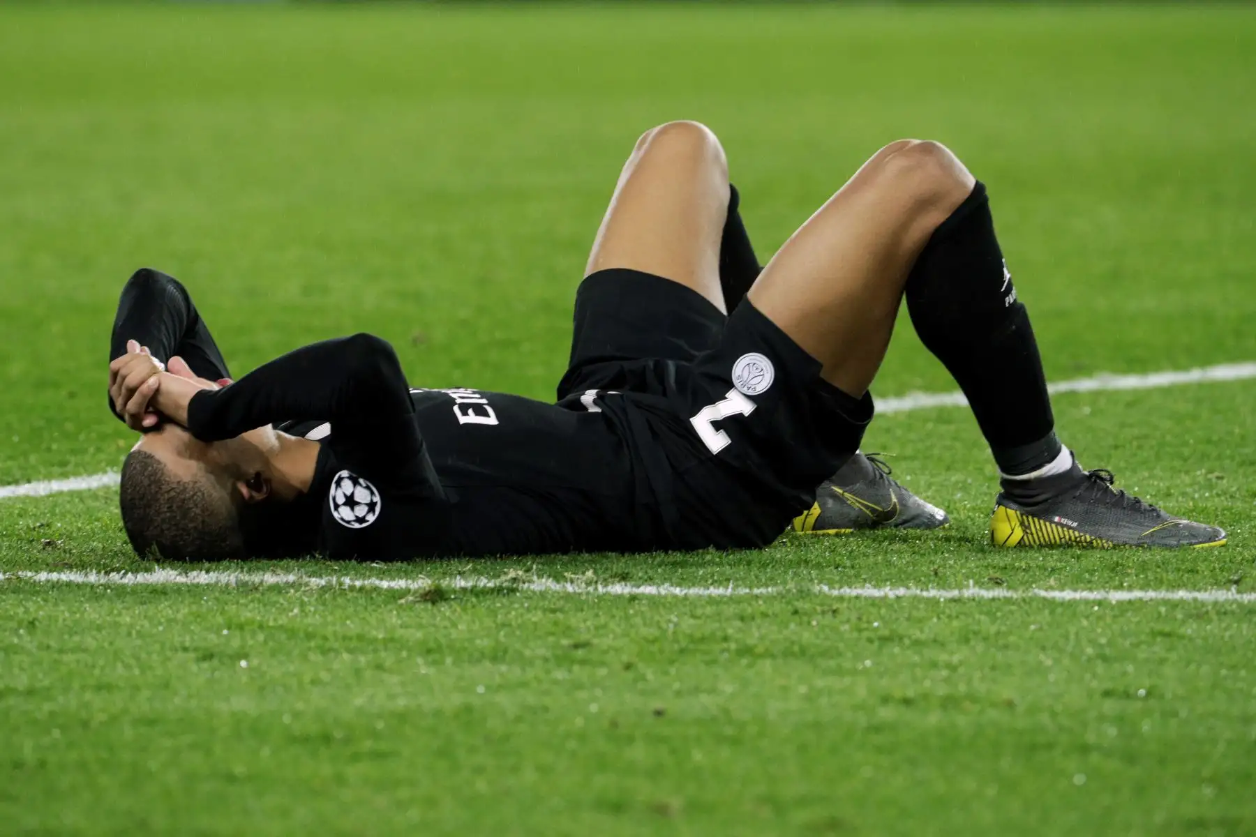 El delantero francés del Paris Saint-Germain, Kylian Mbappe, se encuentra en el campo tras la eliminación de su equipo de la copa UEFA Champions League. Foto: AFP