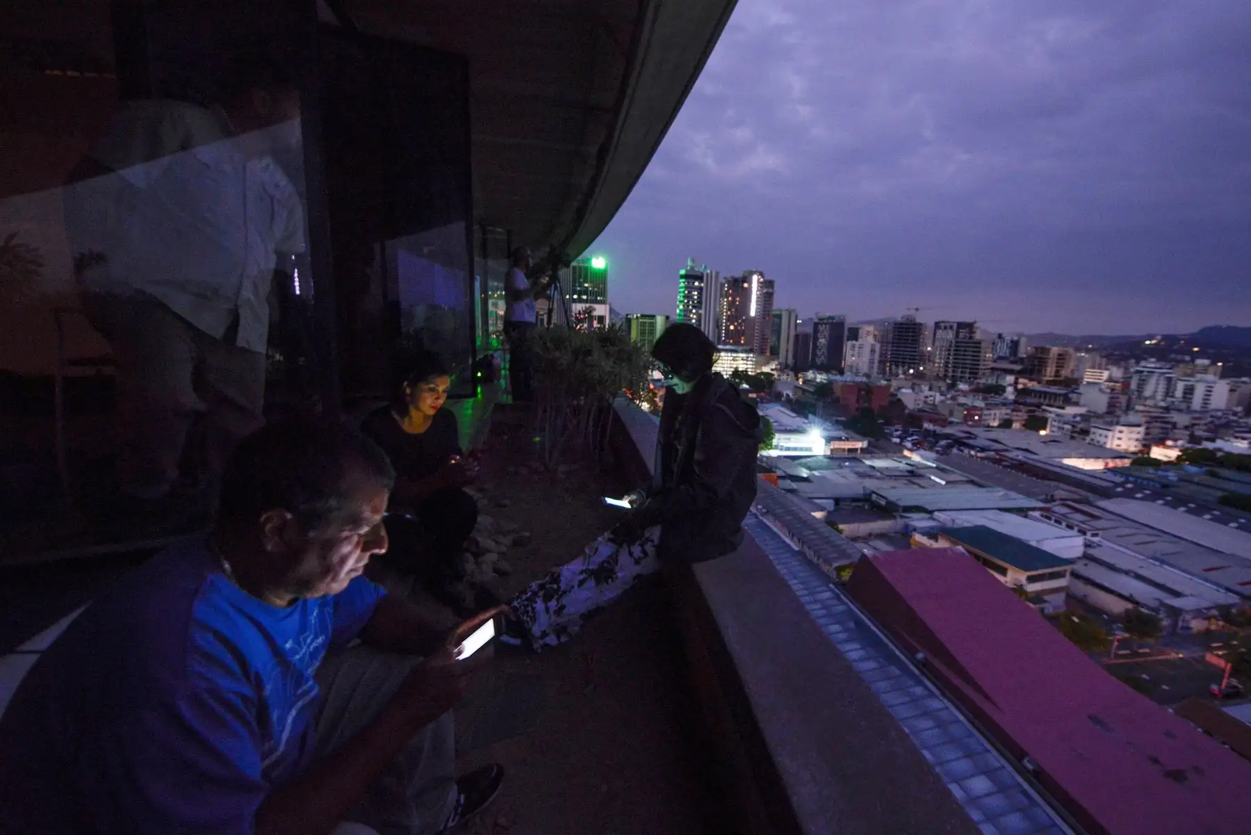 Los periodistas usan sus teléfonos inteligentes durante un corte de energía en Caracas. El gobierno de Nicolás Maduro denunció un "sabotaje" contra la principal represa de energía eléctrica en el país, luego de que un apagón masivo dejara a Caracas y vastas regiones de Venezuela en el país. oscuridad.Foto: AFP