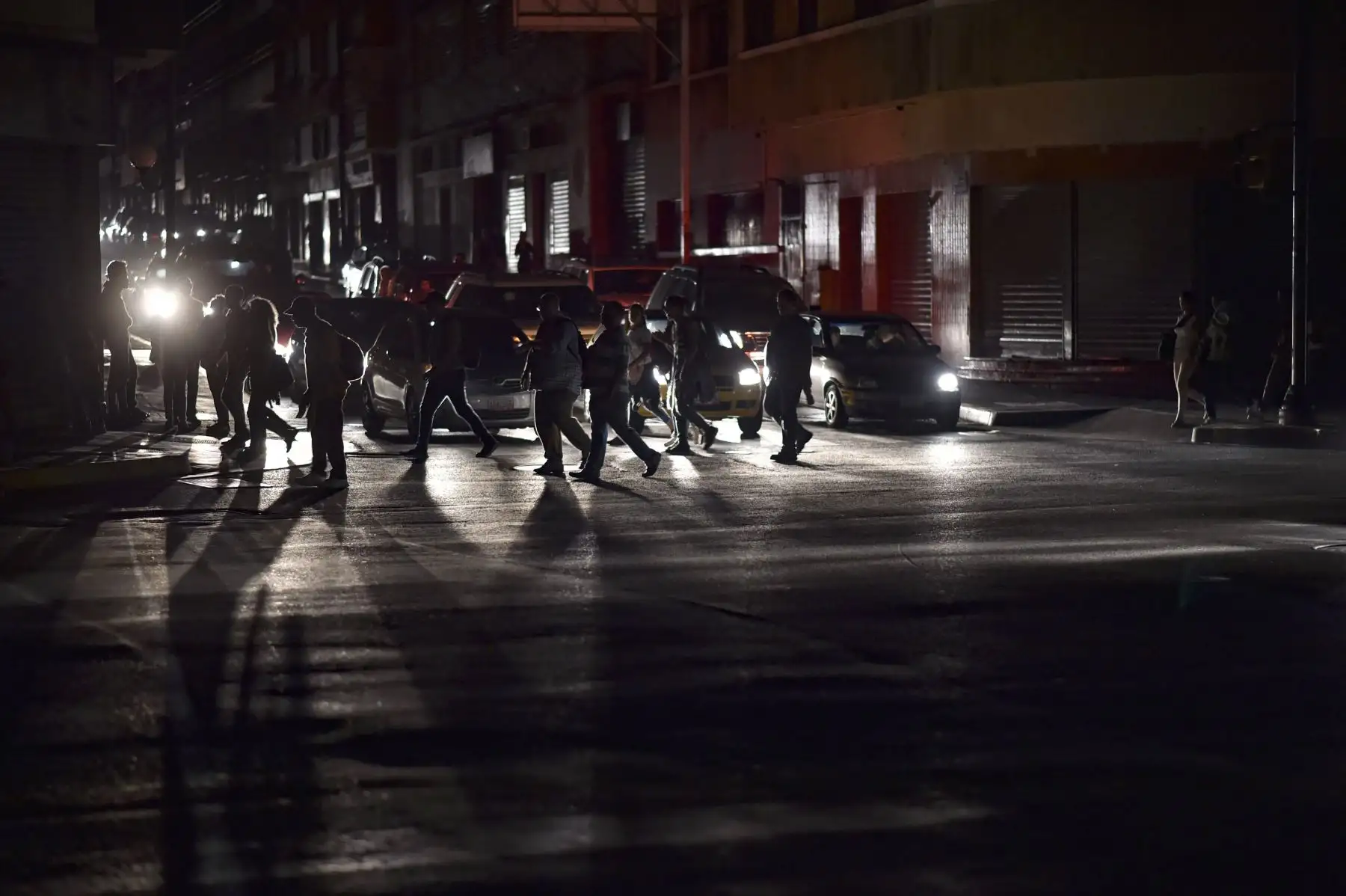La gente cruza una calle durante un corte de energía, luego de que un apagón masivo dejara a Caracas y vastas regiones de Venezuela en la oscuridad .Foto: AFP