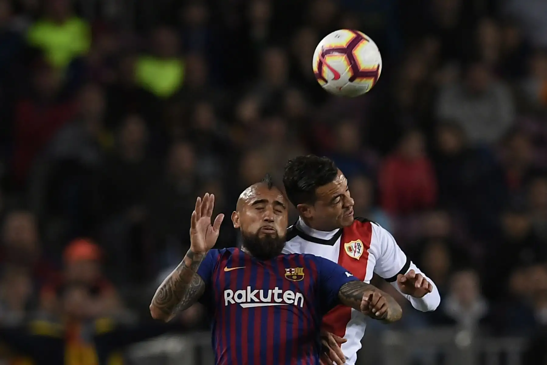 El mediocampista chileno de Barcelona Arturo Vidal (L) y el delantero español de Rayo Vallecano Raúl de Tomas saltan a la pelota durante el partido de fútbol de la liga española entre el FC Barcelona y el Rayo Vallecano.Foto:AFP