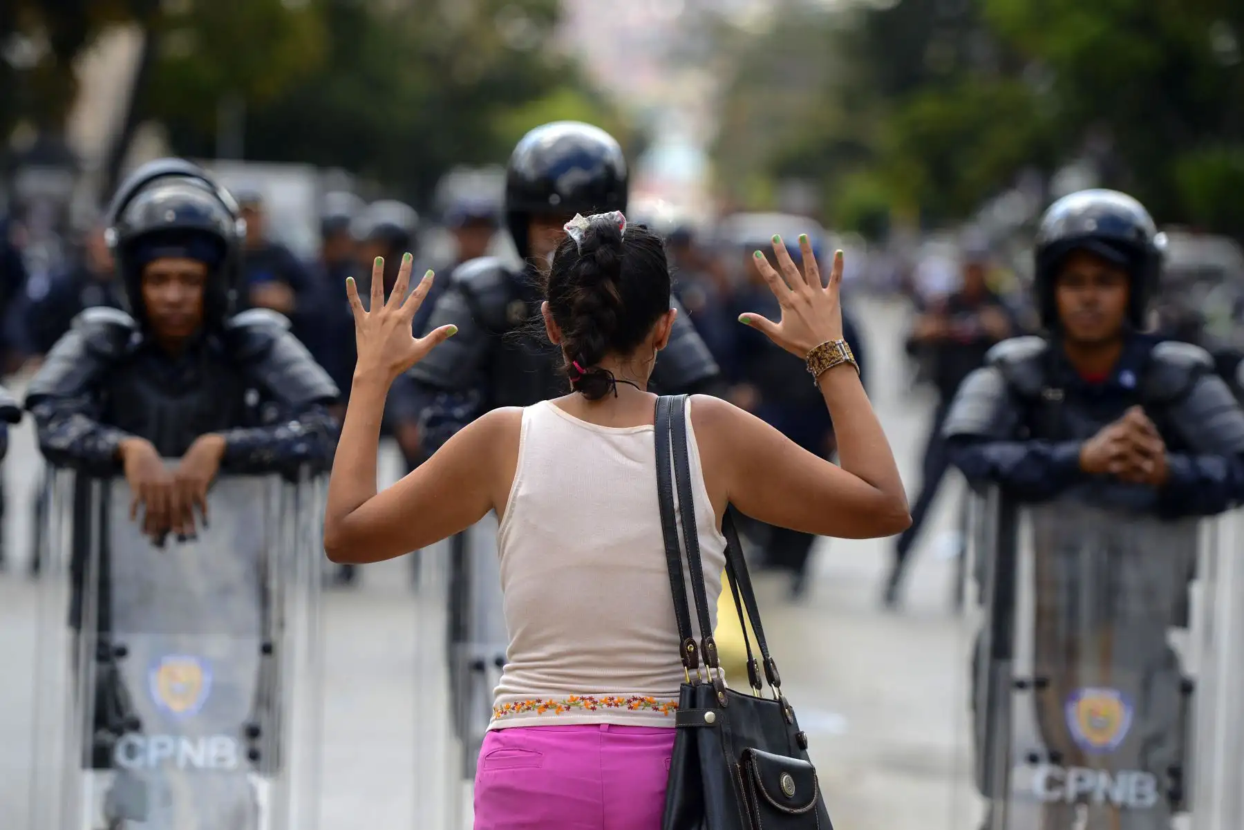 Un partidario del líder opositor venezolano y autoproclamado presidente interino Juan Guaido, se para frente a una línea de policías antidisturbios nacionales bolivarianos durante una manifestación en Caracas.Foto: AFP