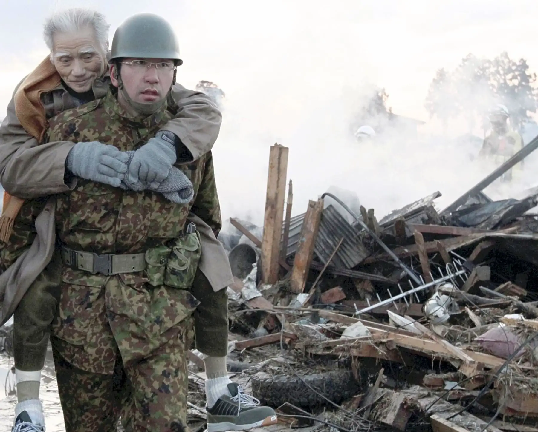 Un soldado carga un anciano a un refugio en la ciudad de Natori, prefectura de Miyagi, el 12 de marzo de 2011. Foto: AFP