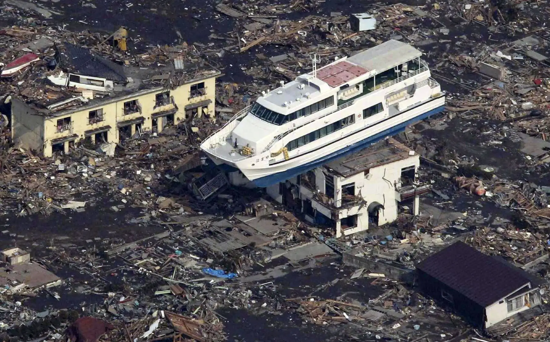 Esta fotografía aérea muestra un bote sobre lo alto de un edificio en medio de un mar de escombros en la ciudad de Otsuchi. Foto: AFP