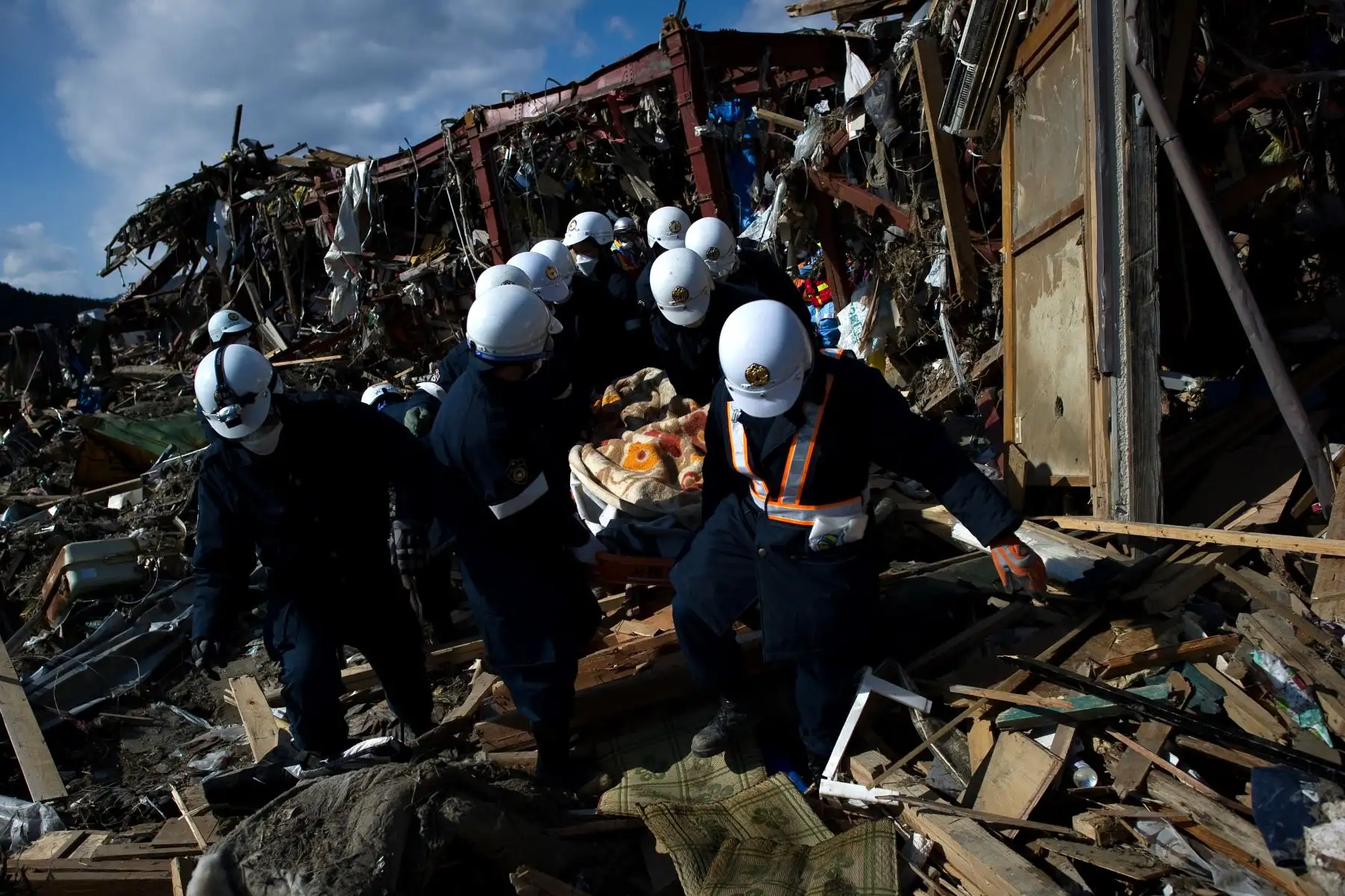 Rescatistas japoneses mueven el cuerpo de una víctima del tsunami el 11 de marzo encontrado en la ciudad de Rikuzentakata. Foto: AFP