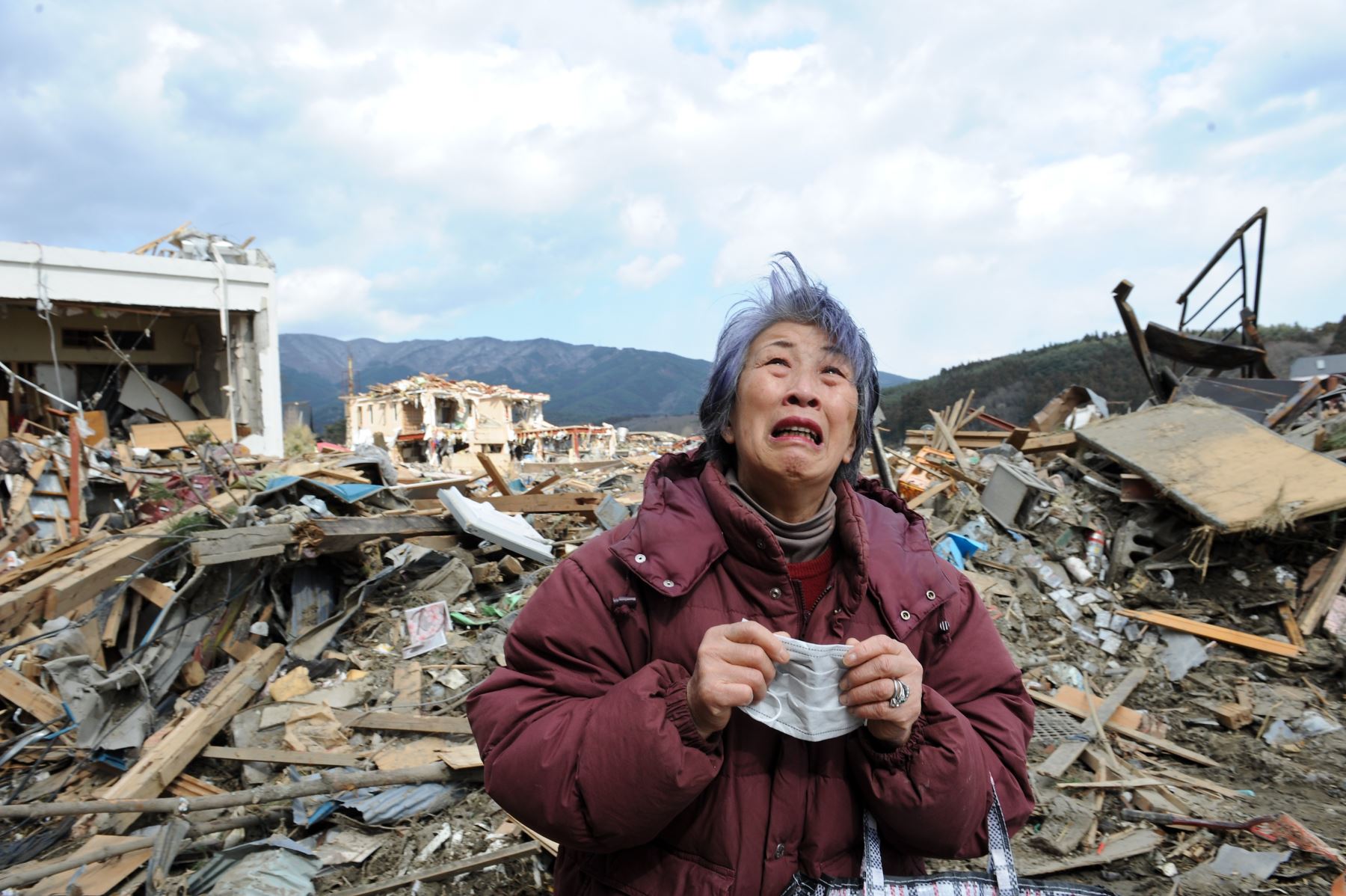 Una anciana llora frente a un edificio destruido en la devastada ciudad de Rikuzentakata, el 19 de marzo de 2011. Foto: AFP