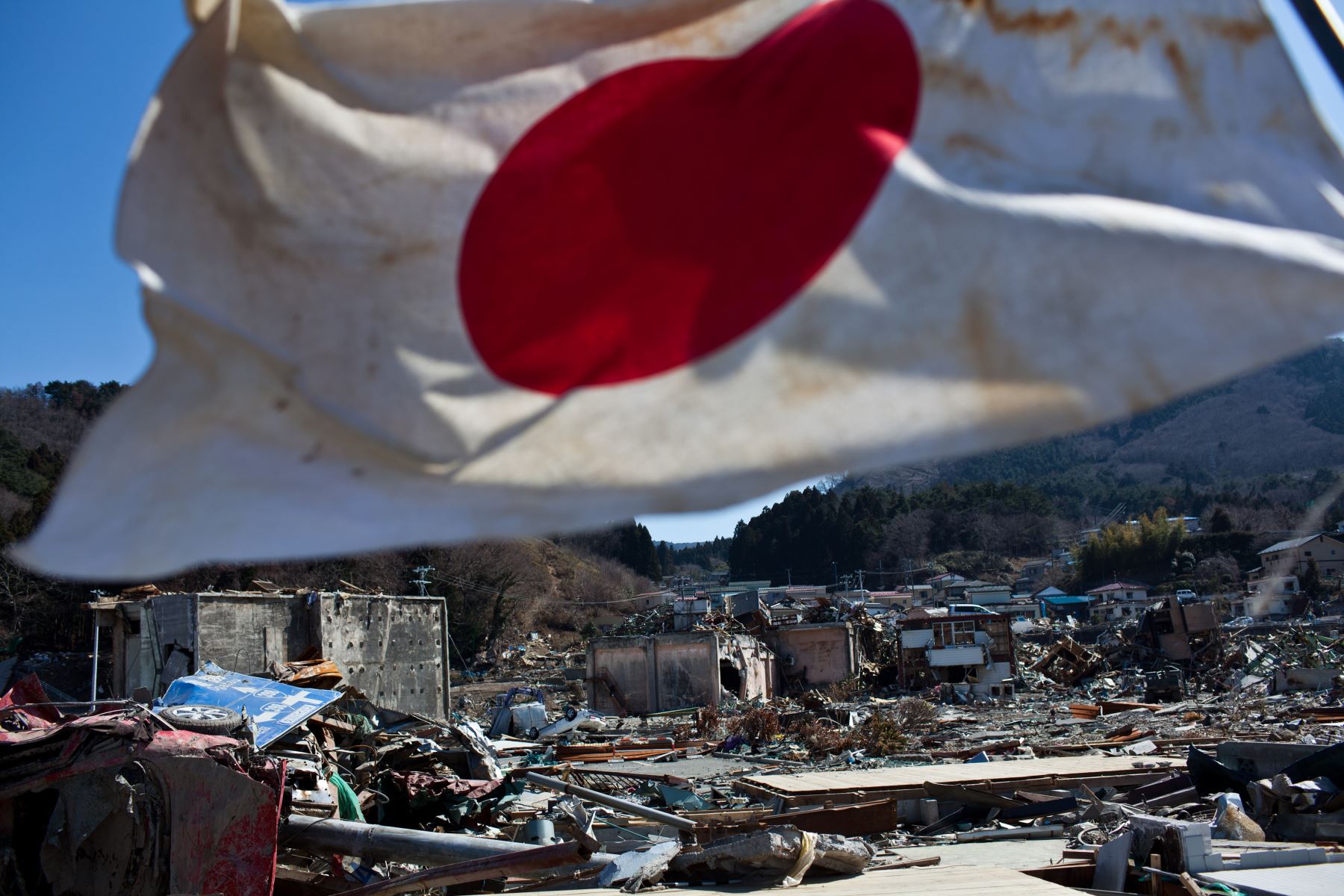 Una bandera japonesa ondea en el viento en medio de los restos y la devastación del tsunami del 11 de marzo en el centro de la ciudad de Onagawa. Foto: AFP