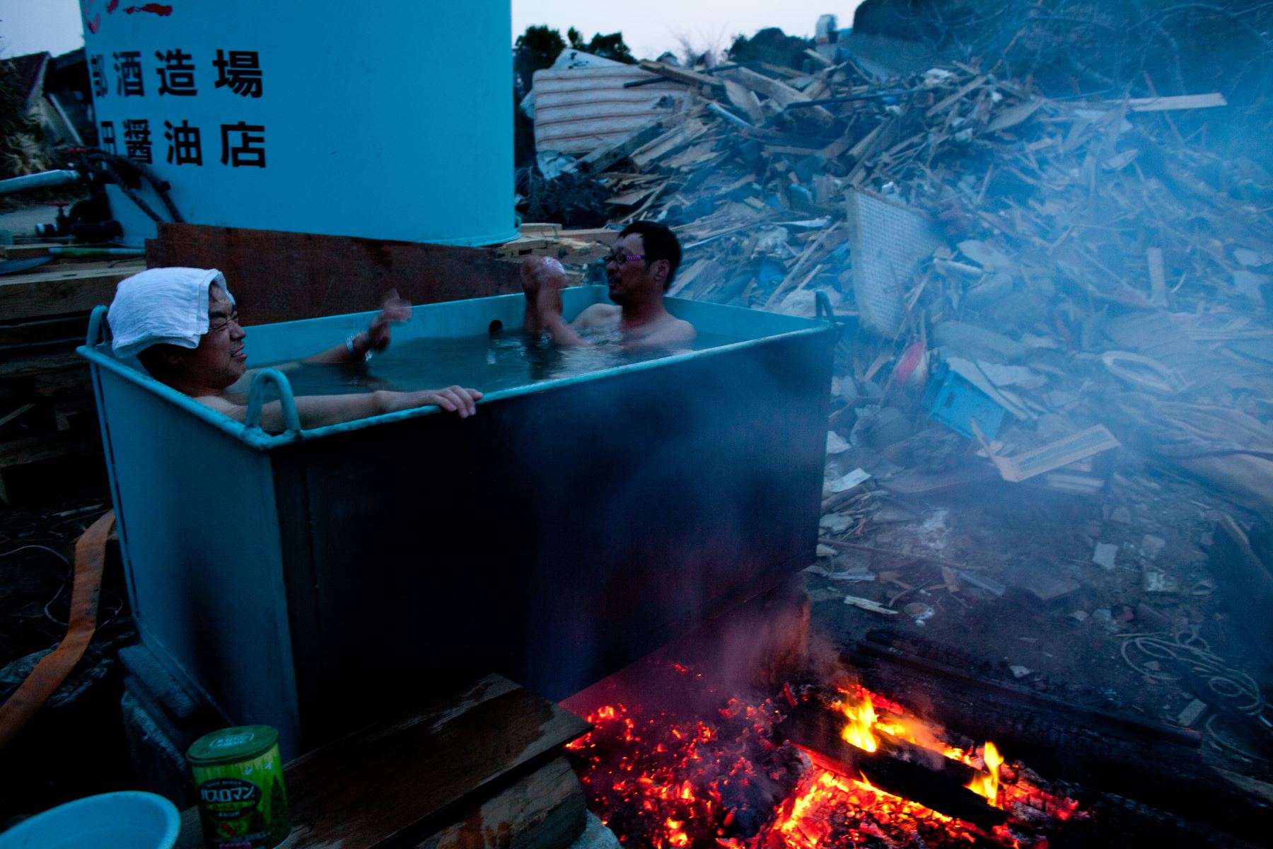 Residentes toman un baño en la puerta de su casa tras la devastación causada por el tsunami en Minamisanriku. Foto: AFP