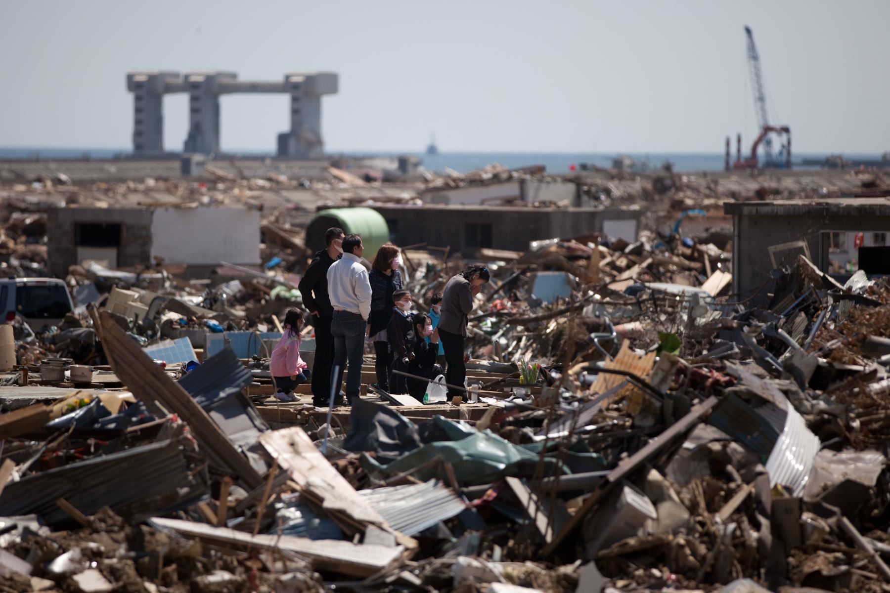 Una familia reza por las víctimas en un área devastada por el tsunami en Rikuzentakata. Foto: AFP