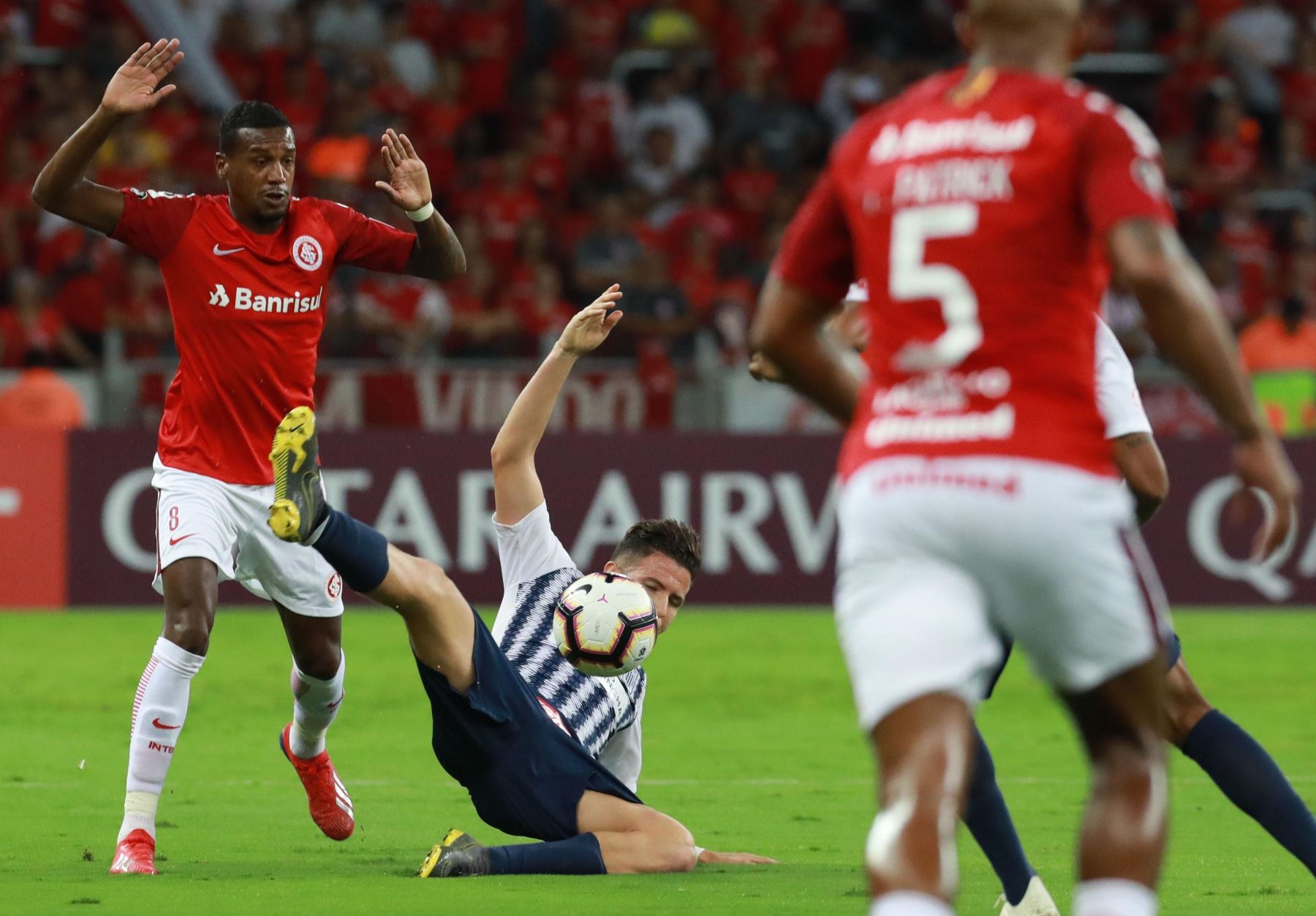 Edenilson  de Internacional disputa el balón con Adrian Ugarriza  de Alianza Lima durante un partido por la fase de grupos de la Copa Libertadores. EFE