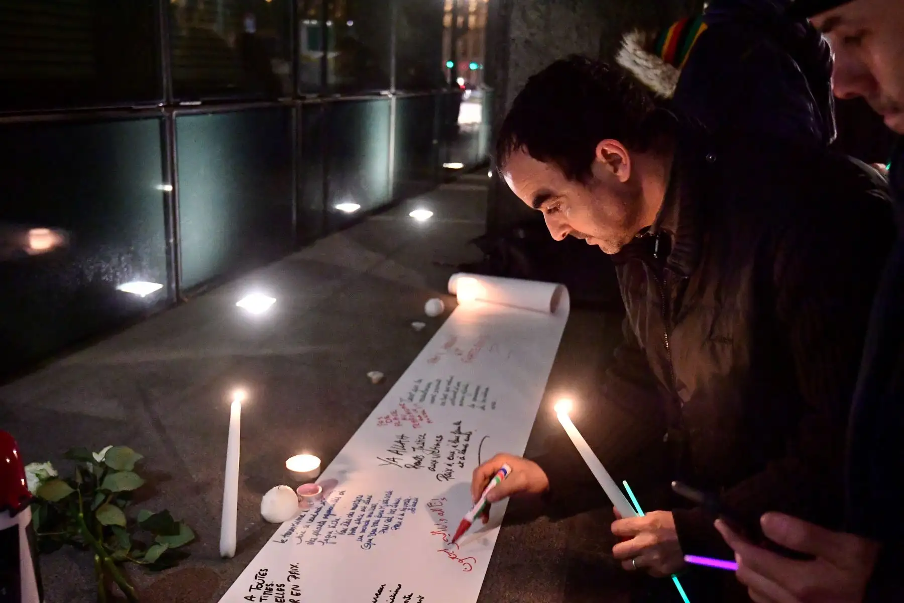 La gente escribe mensajes en una hoja de papel durante una reunión para conmemorar a las víctimas de un ataque a dos mezquitas en Nueva Zelanda. Foto: AFP