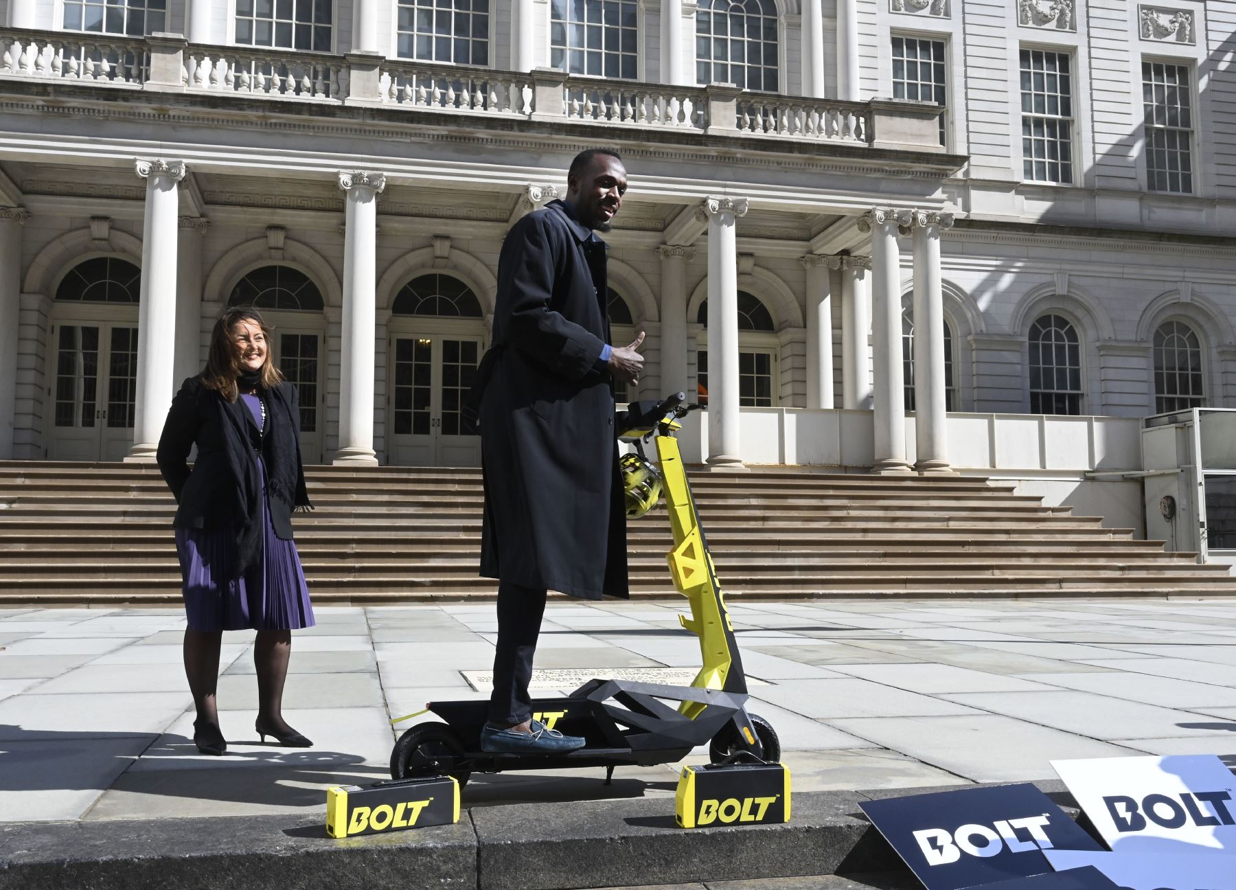El velocista medallista de oro olímpico Usain Bolt, el portavoz mundial de Bolt, Mobility; junto con la cofundadora de Bolt, Sarah Haynes, presenta el "scooter" eléctrico personal Bolt Mobility. Foto: AFP.