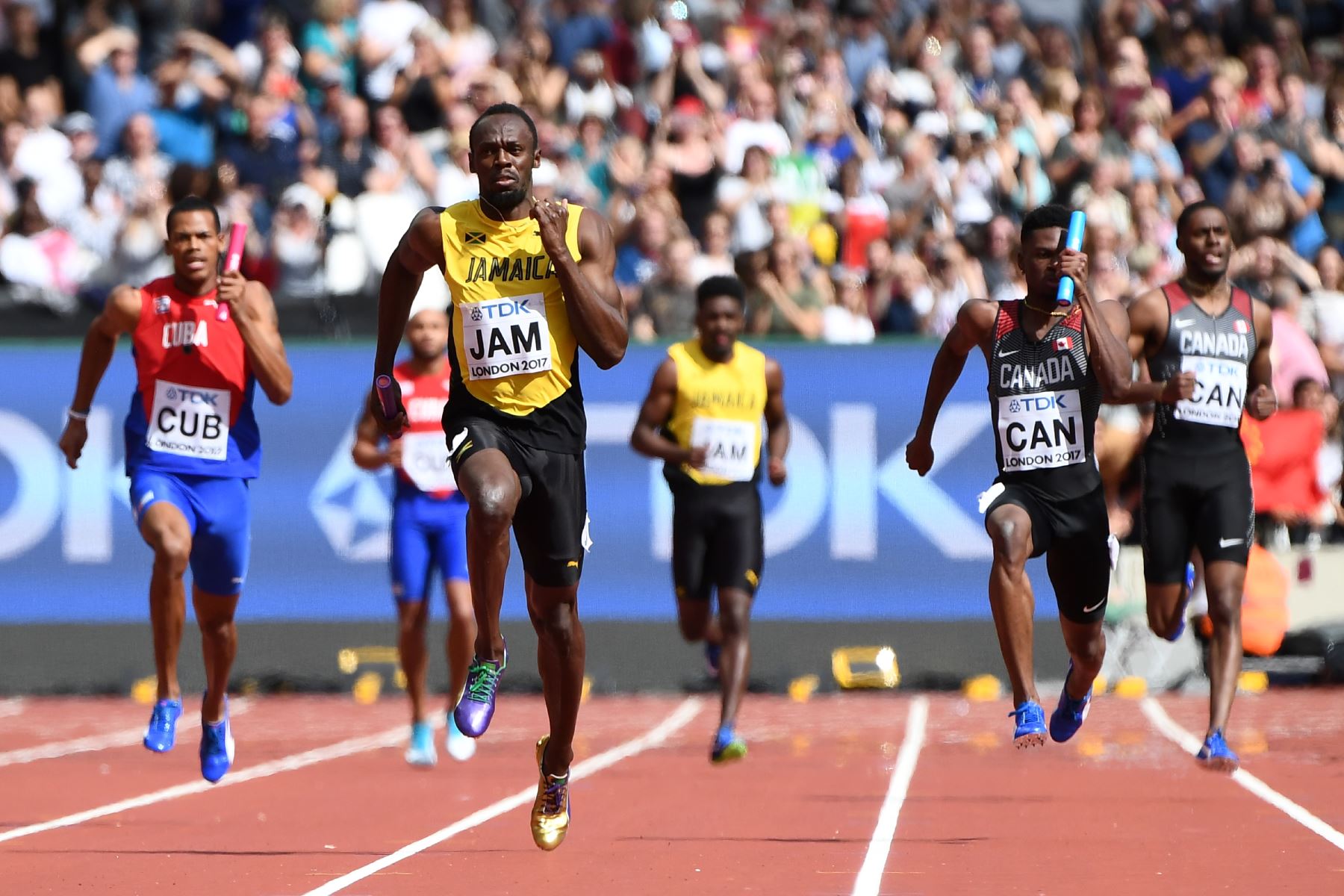 Usain Bolt (c), de Jamaica, corre hacia la línea de meta en la pierna de anclaje delante de Mobolade Ajomale (d) de Canadá y José Luis Gaspar (i), de Cuba, para ganar su calor en el evento de atletismo de relevos 4x100 metros masculino en Londres. Foto: AFP.