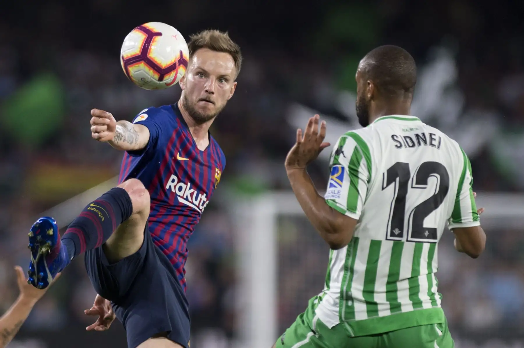 El centrocampista croata de Barcelona Ivan Rakitic (L) compite con el defensor brasileño del Real Betis Sidnei durante el partido de fútbol de la liga española entre el Real Betis y el FC Barcelona.Foto:AFP