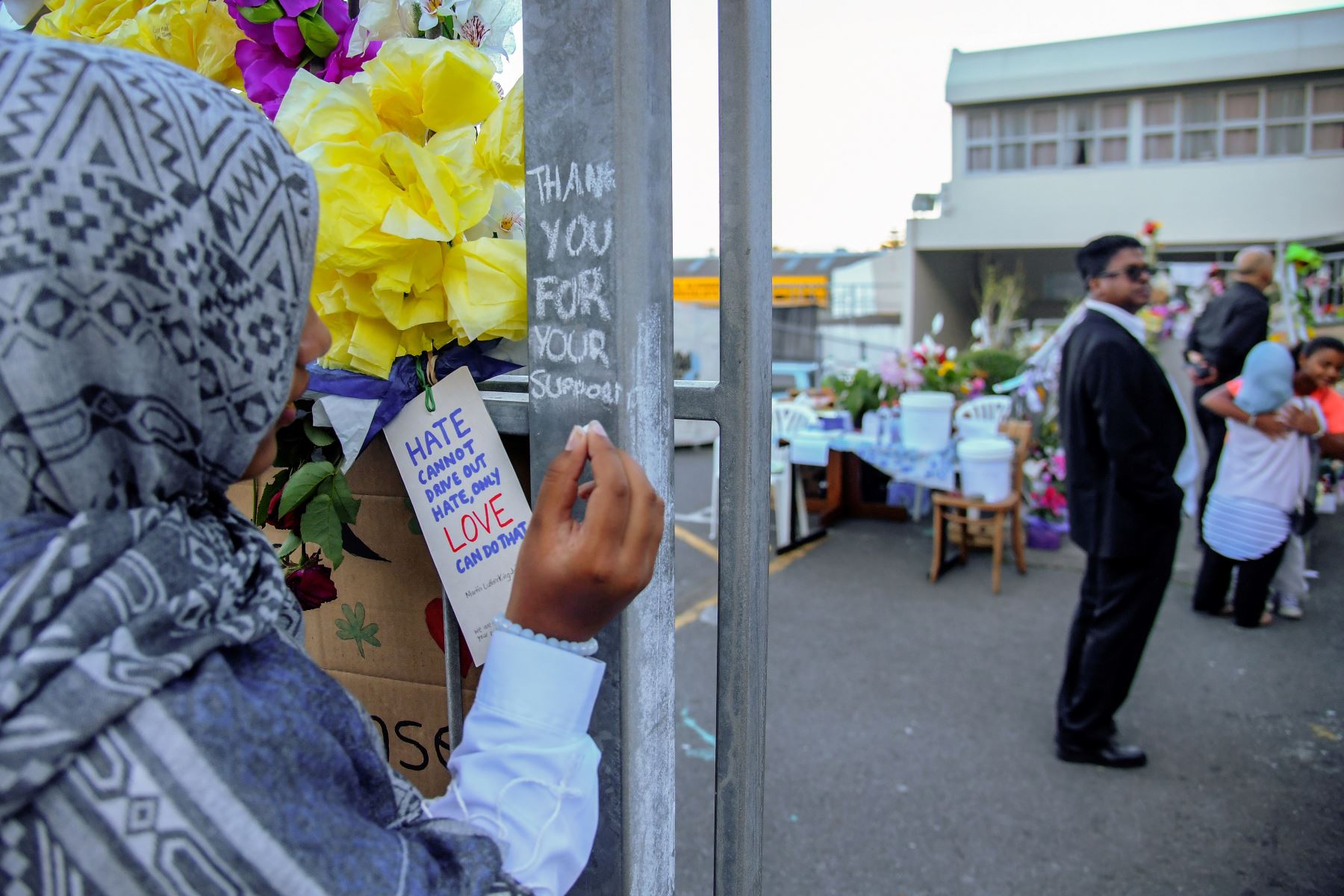 Una niña musulmana escribe un mensaje para rendir homenaje a las víctimas de los ataques a la mezquita de Christchurch. Foto: AFP