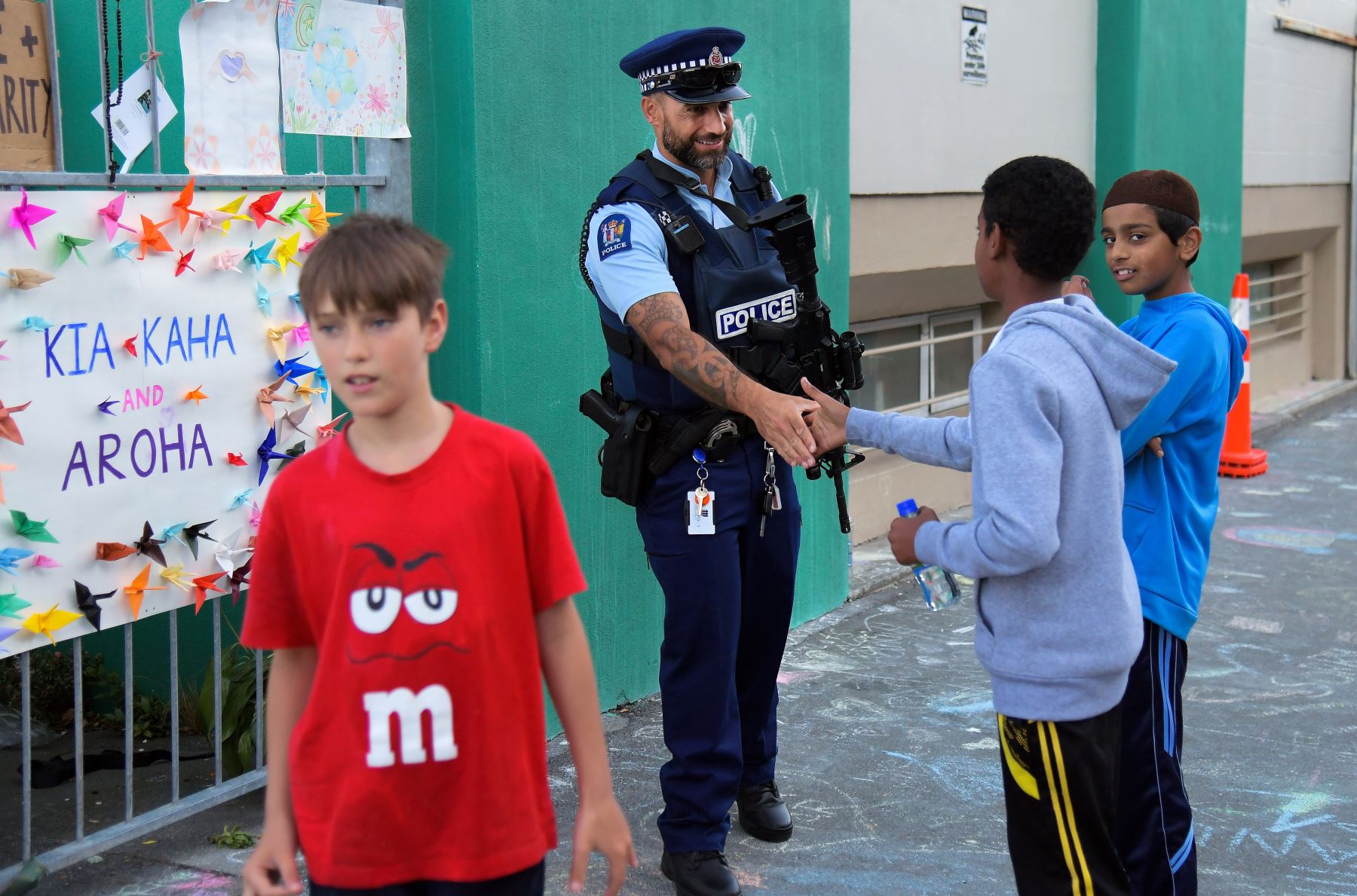 Un oficial de la policía da la mano a los niños de la comunidad musulmana en un Centro Islámico en Kilbirnie, Wellington. Foto: AFP