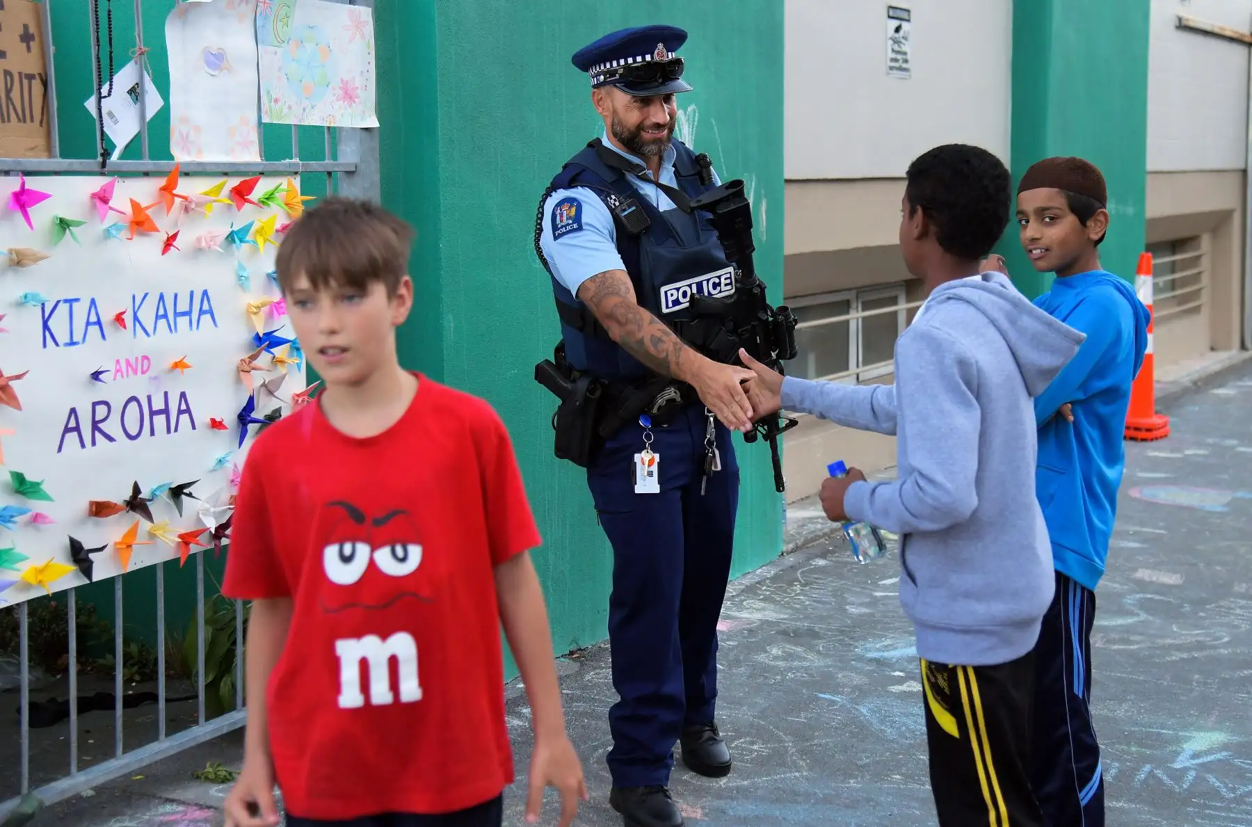 Un oficial de la policía da la mano a los niños de la comunidad musulmana en un Centro Islámico en Kilbirnie, Wellington. Foto: AFP