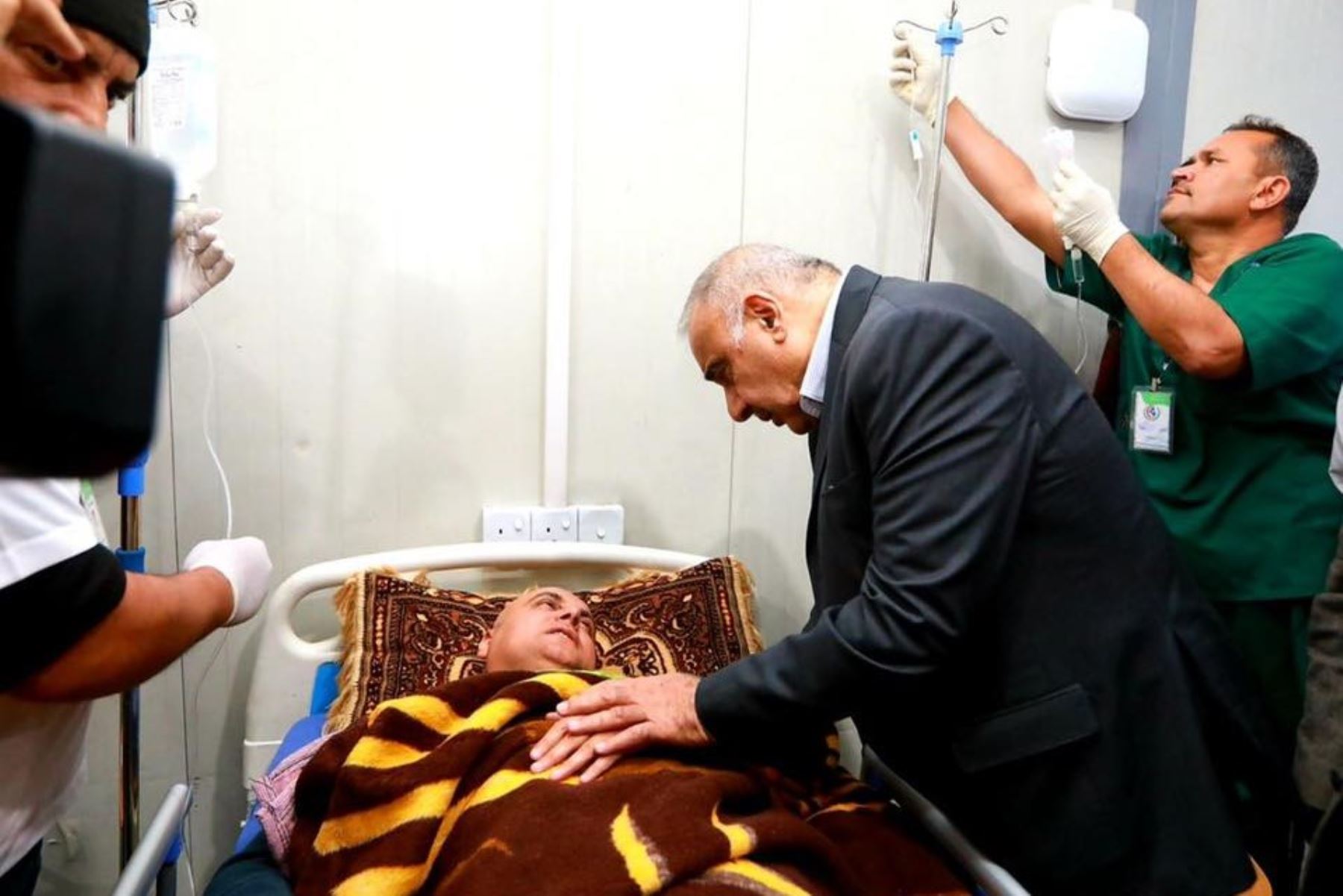 El primer ministro iraquí Adel Abdel Mahdi visita a un hombre que sobrevivió al hundimiento del ferry del río Tigris, en un hospital en Mosul el 21 de marzo de 2016. Foto: AFP
