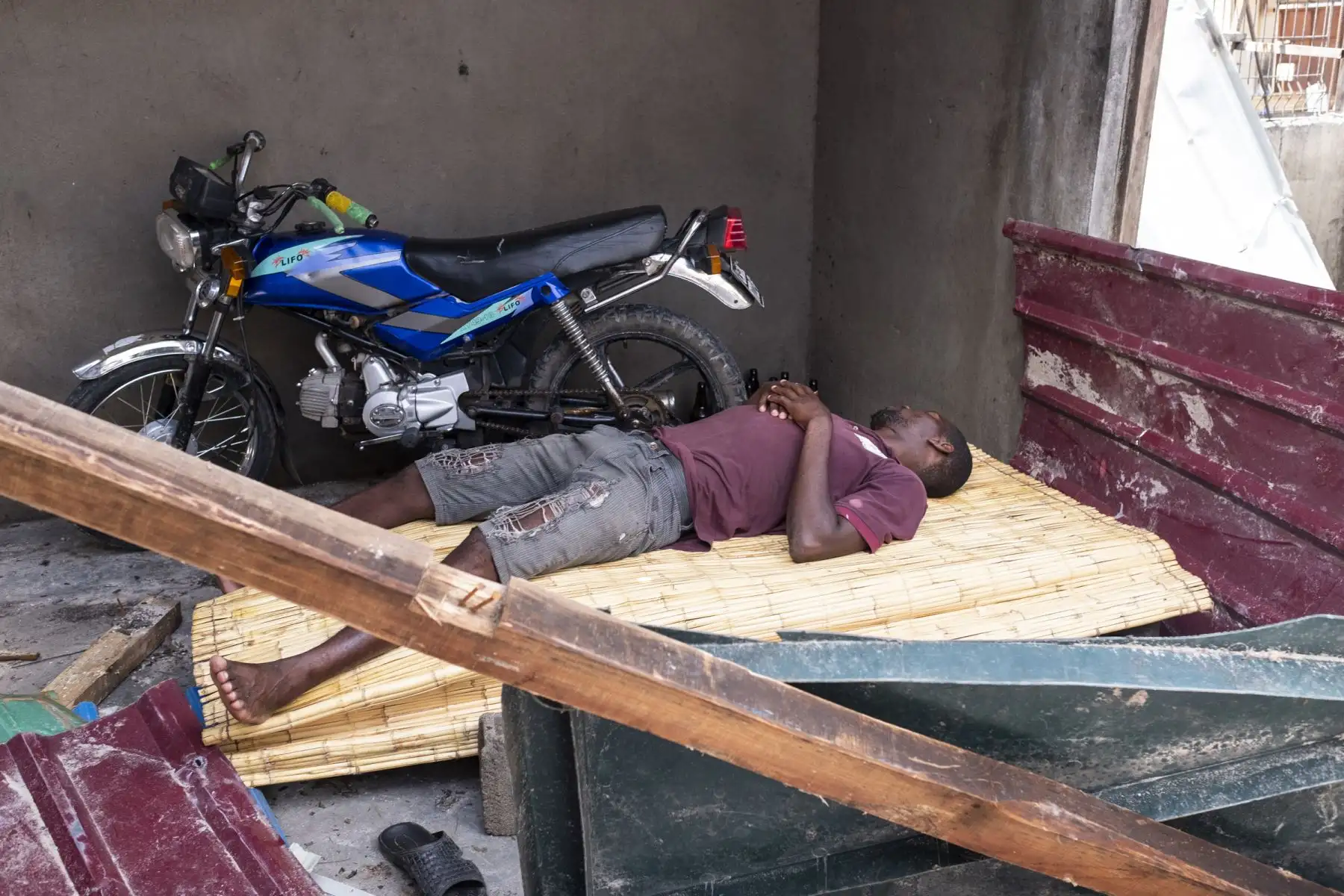 Un hombre yace en una estera de bambú dentro de una casa dañada en el área de Estoril en Beira. El ciclón Idai se estrelló contra la costa de Mozambique desatando una fuerza de huracanes y la lluvia que inundó las franjas del país pobre antes de atacar el este de Zimbabwe. matando a 705 personas en las dos naciones.Foto: AFP