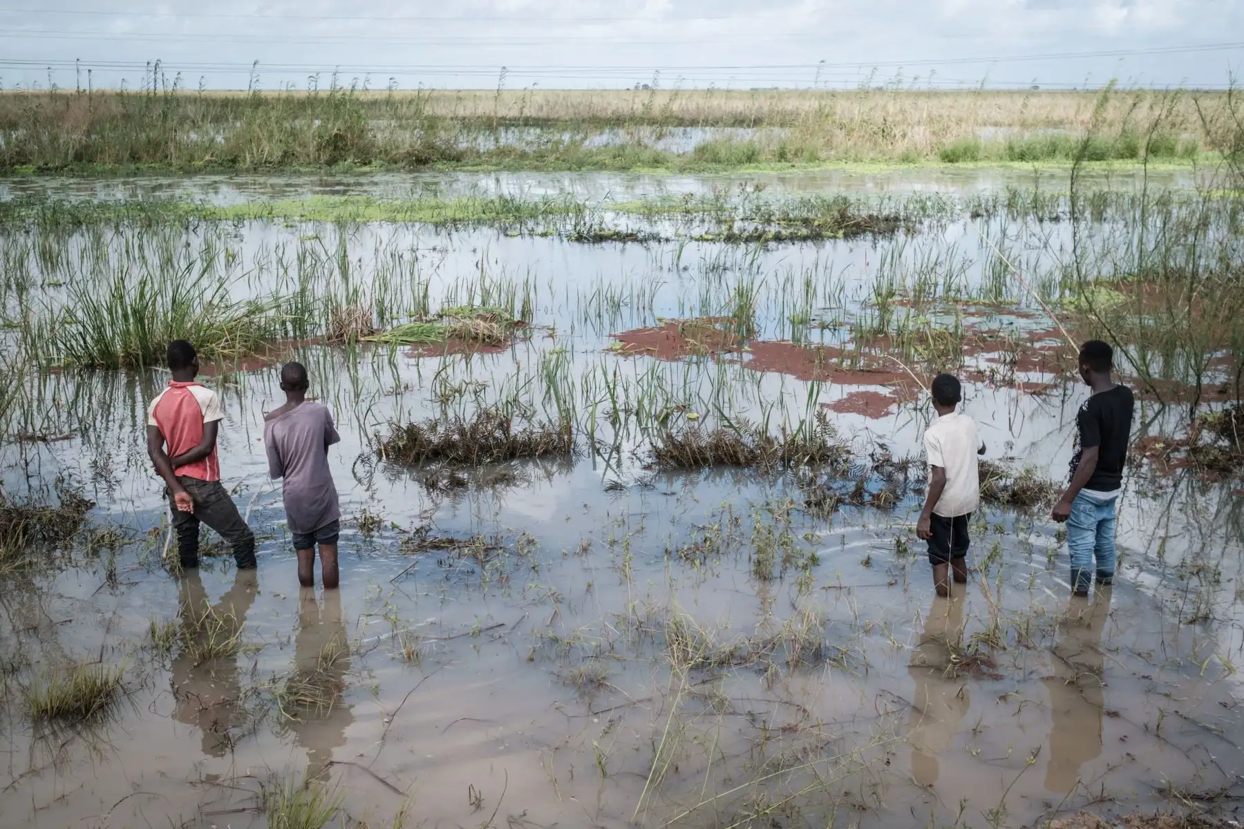 Los muchachos pescan en un área inundada después del paso del ciclón Idai cerca de Tica.Foto: AFP