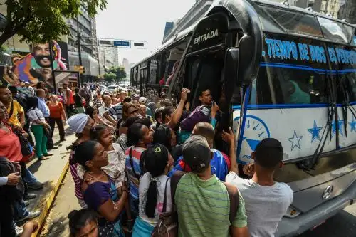 El 25 de marzo de 2019, la gente hace cola para subirse a un autobús durante un corte de energía parcial en Caracas. Foto: AFP