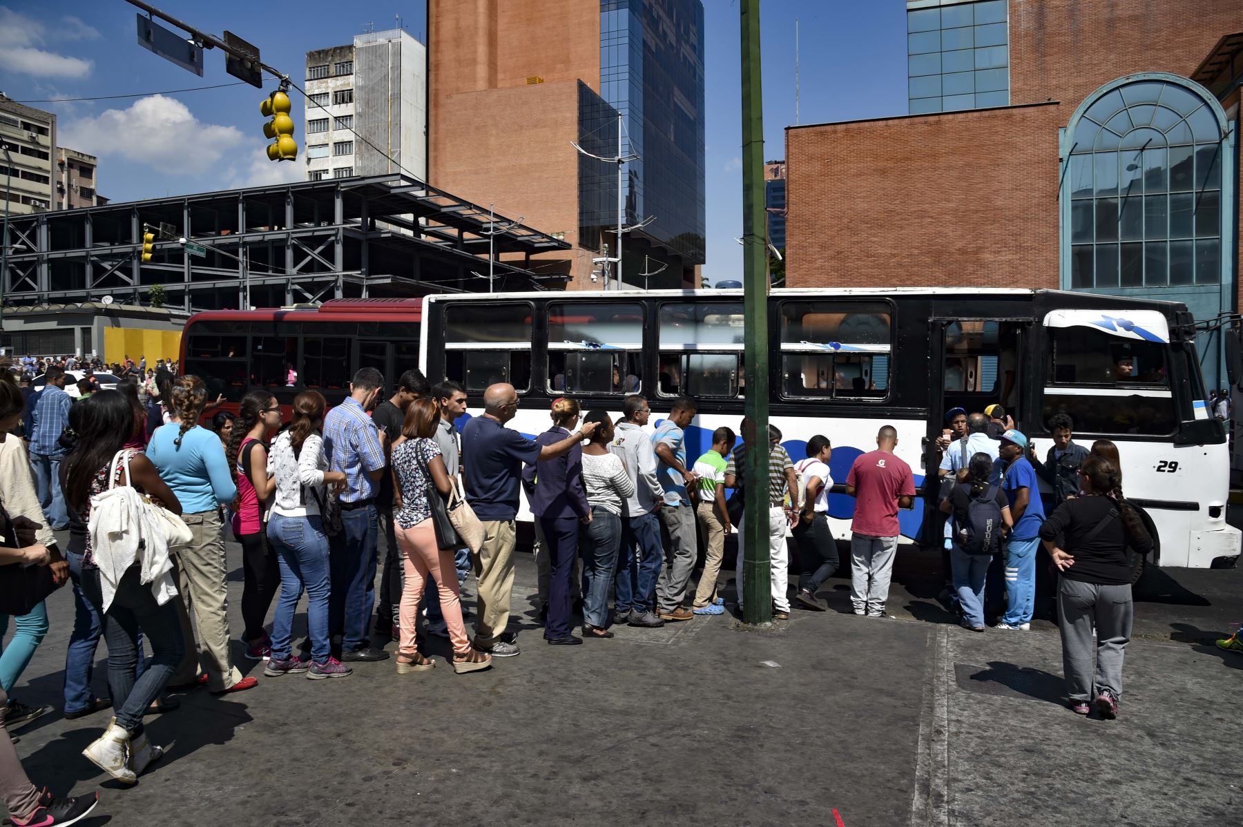 El 25 de marzo de 2019, la gente hace cola para subirse a un autobús durante un corte de energía parcial en Caracas. Foto: AFP
