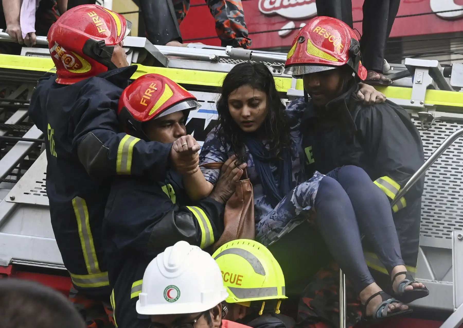 Sobrevivientes son rescatados por bomberos tras el incendio en un  edificio en Dhaka. Foto: AFP
