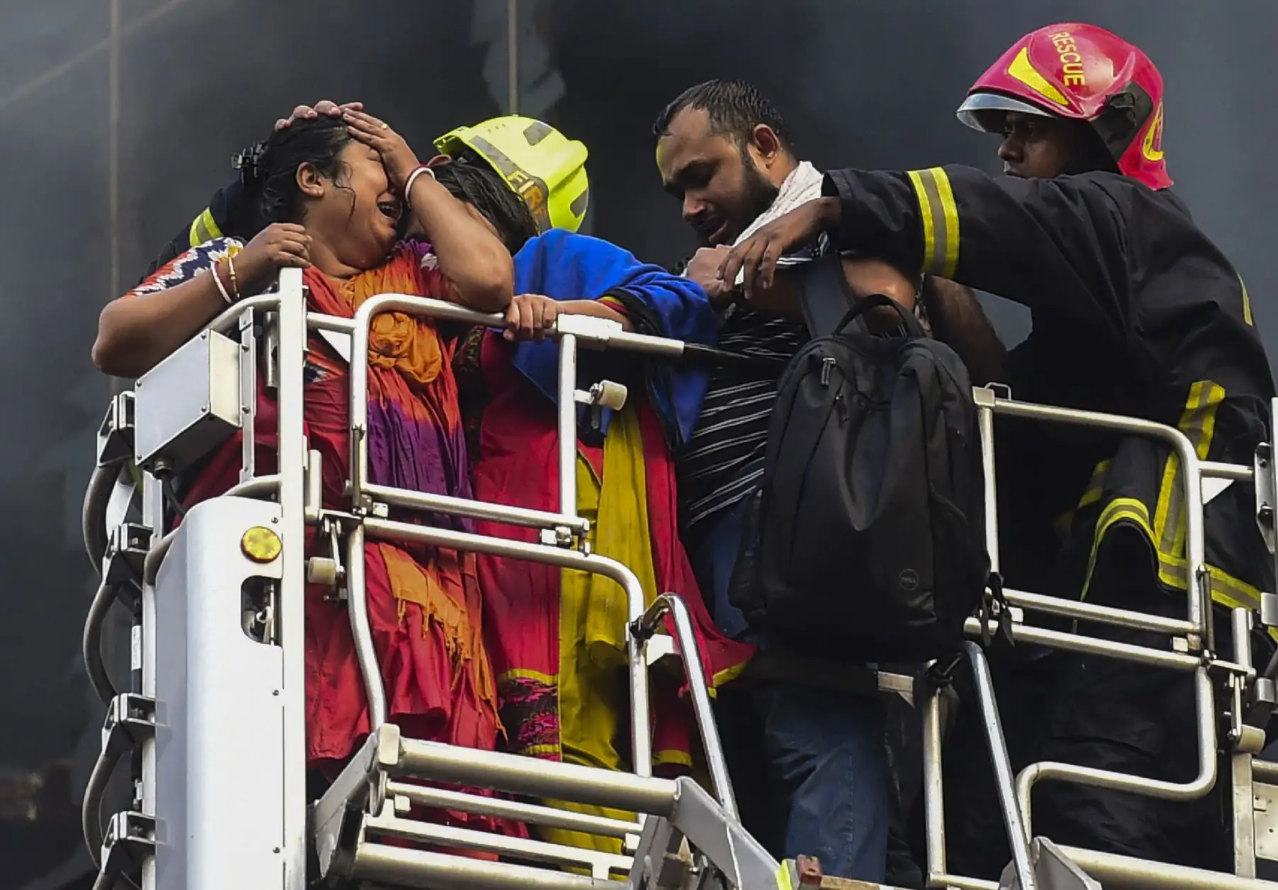 Sobrevivientes son rescatados por bomberos tras el incendio en un  edificio en Dhaka. Foto: AFP