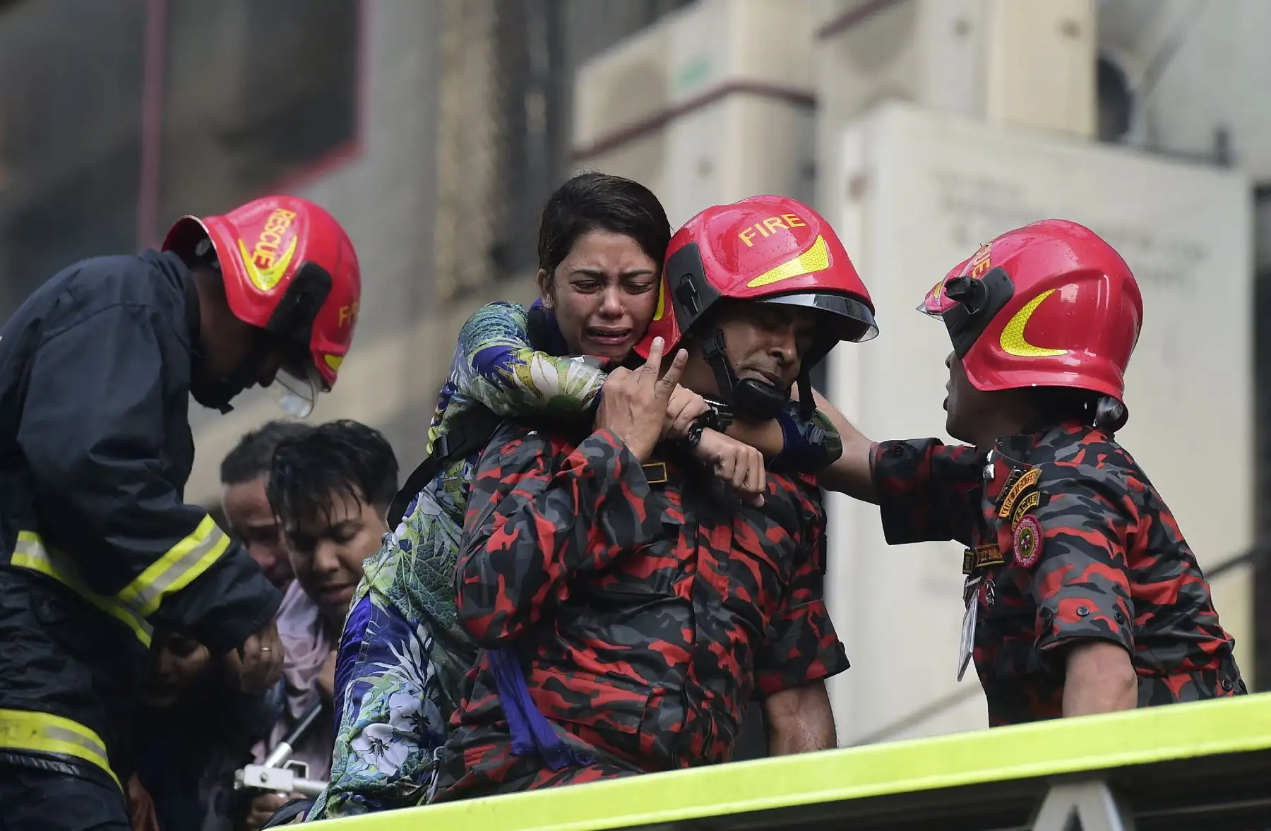 Sobrevivientes son rescatados por bomberos tras el incendio en un  edificio en Dhaka. Foto: AFP