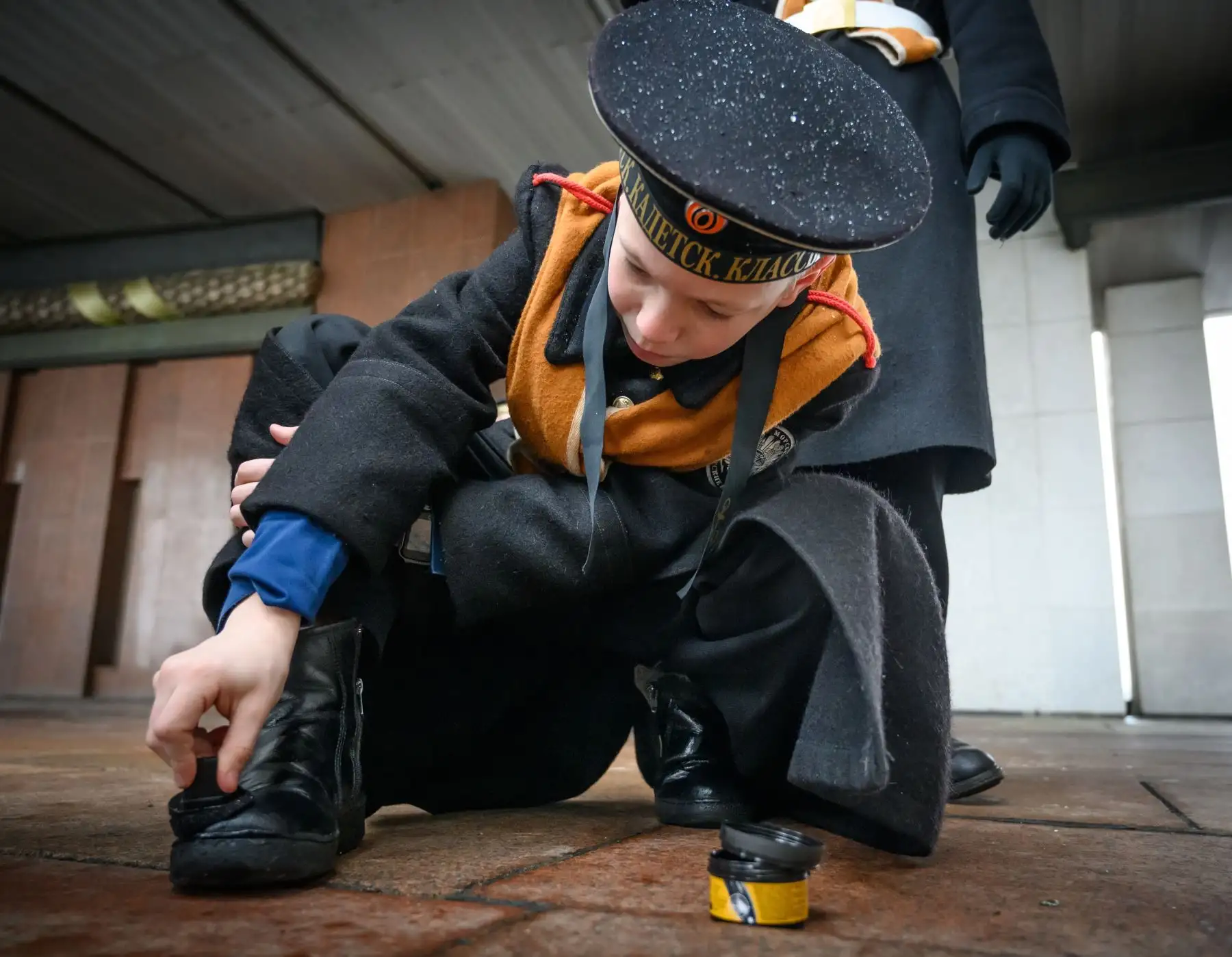 Un cadete ruso lustra sus zapatos durante la reunión anual de escuelas de cadetes en Moscú. Foto: AFP