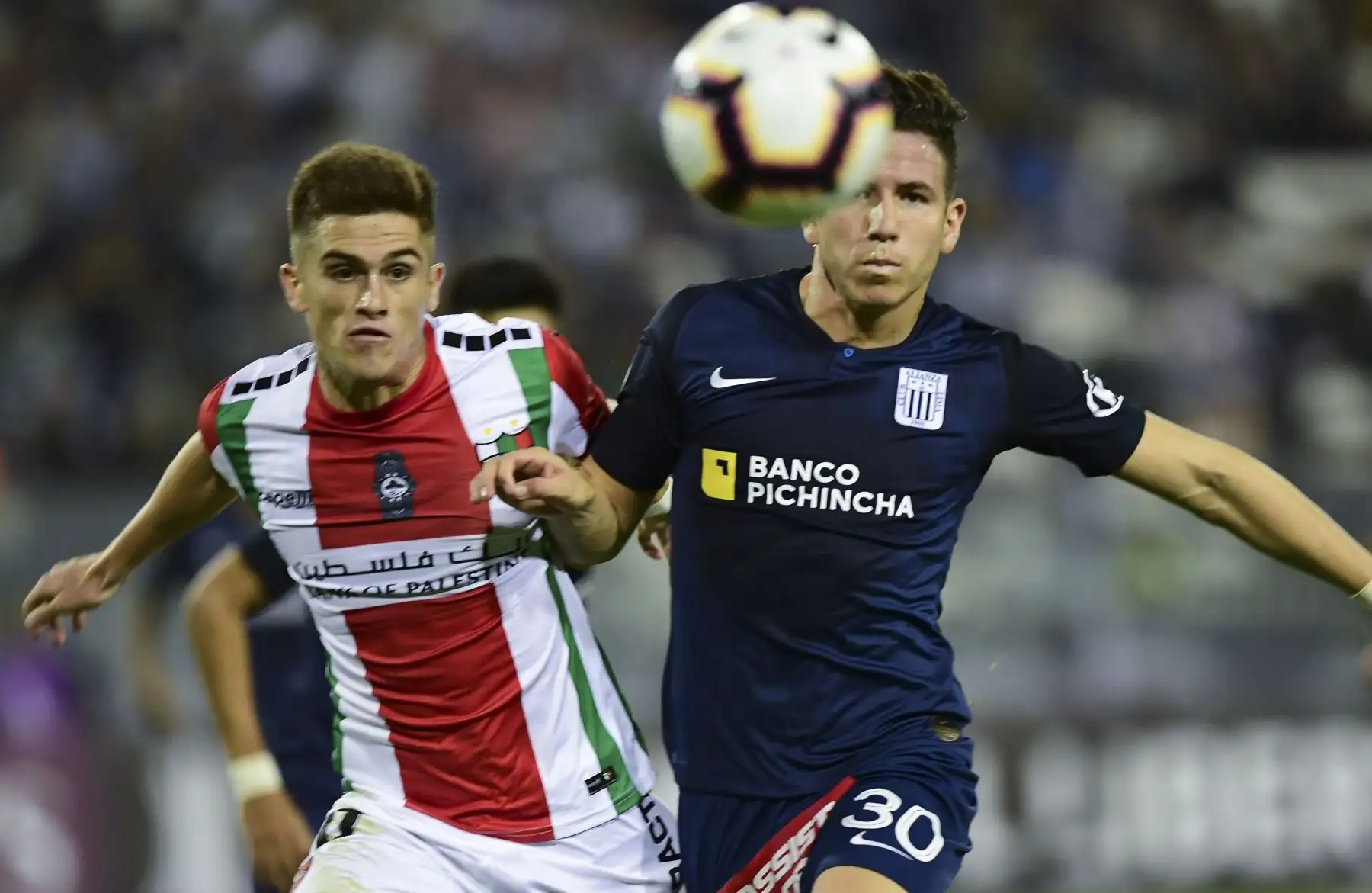 El palestino chileno Guillermo Soto (L) compite por el balón contra la Alianza Lima Adrian Ugarriza (R) de Perú durante su partido de fútbol de la Copa Libertadores 2019 en el estadio Monumental de Santiago de Chile.Foto: ANDINA/AFP