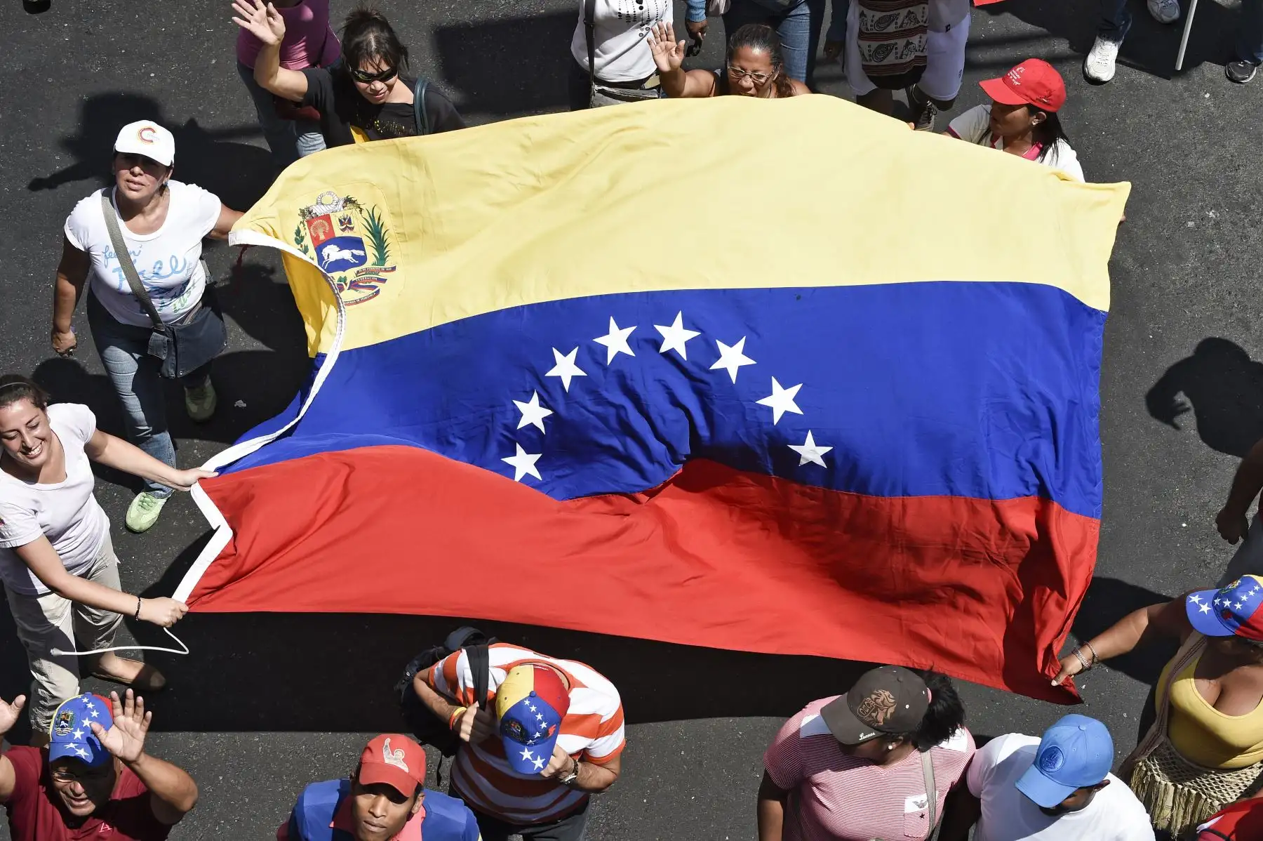 Los partidarios del presidente venezolano Nicolás Maduro participan en un mitin con una bandera nacional venezolana en Caracas. Foto: ANDINA/AFP