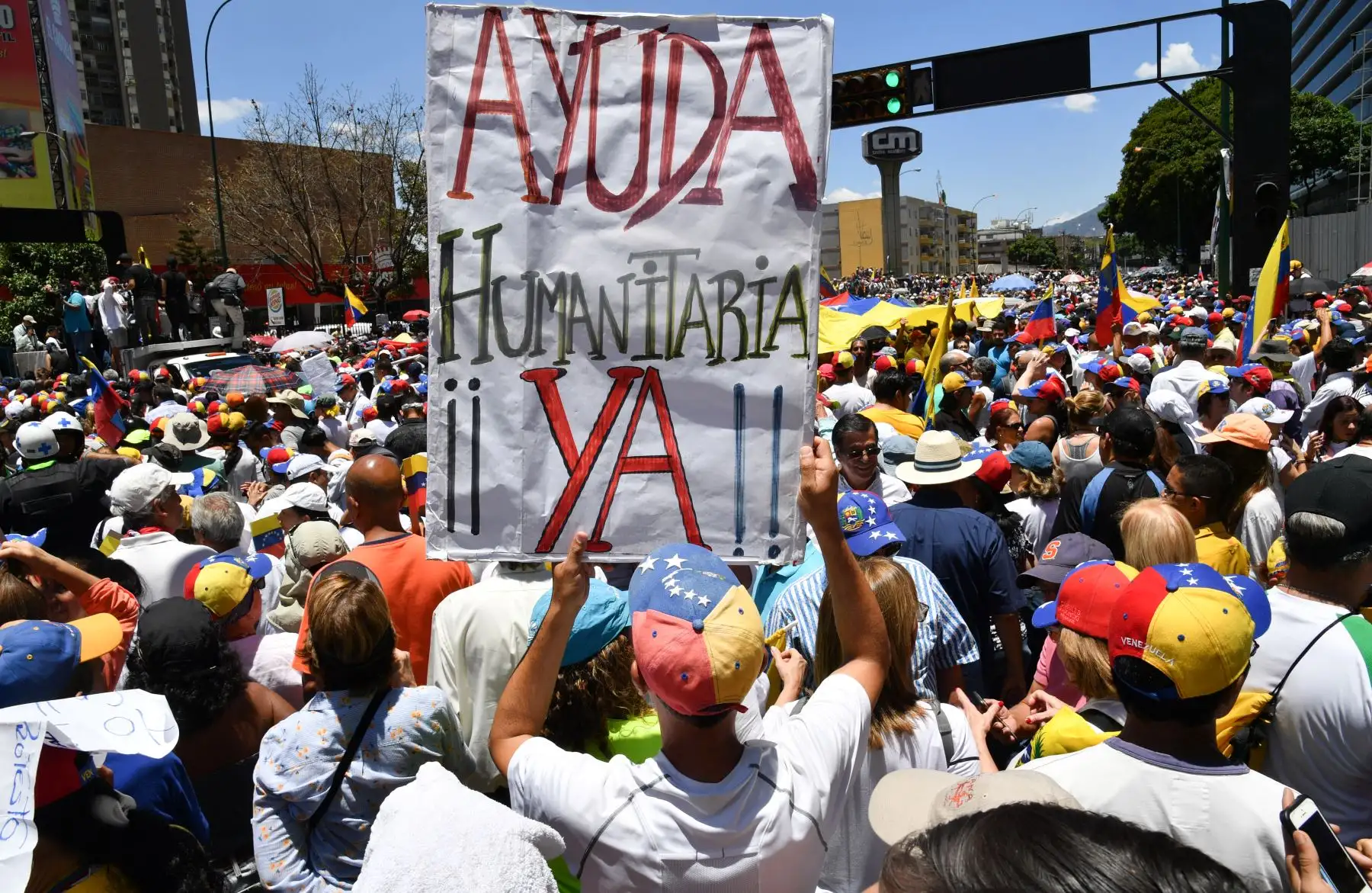 Los partidarios del líder opositor venezolano y el autoproclamado presidente interino Juan Guaido participan en una demostración con un cartel que dice "¡Ayuda humanitaria ahora!" en Caracas.Foto:AFP