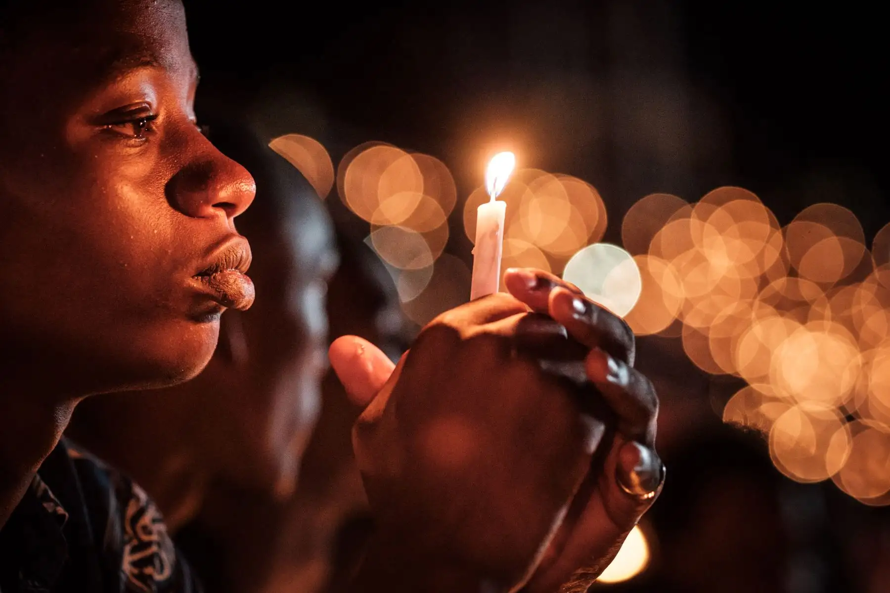 Una persona sostiene una vela durante una vigilia nocturna como parte de la 25ª Conmemoración del Genocidio de 1994, en Kigali, Ruanda. Foto: AFP