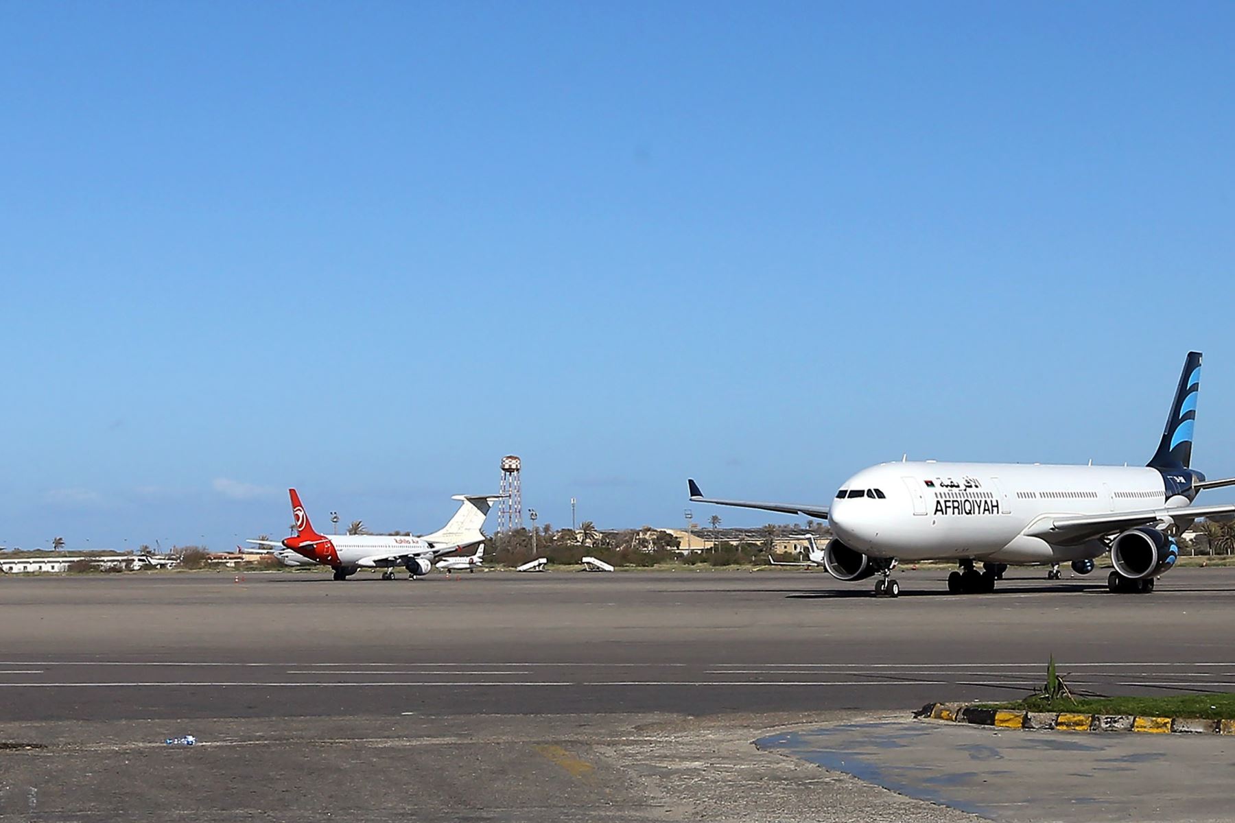 Aviones descansan en la pista después de un ataque aéreo en el Aeropuerto Internacional Mitiga en la capital libia, Trípoli el 8 de abril de 2019. Foto: AFP