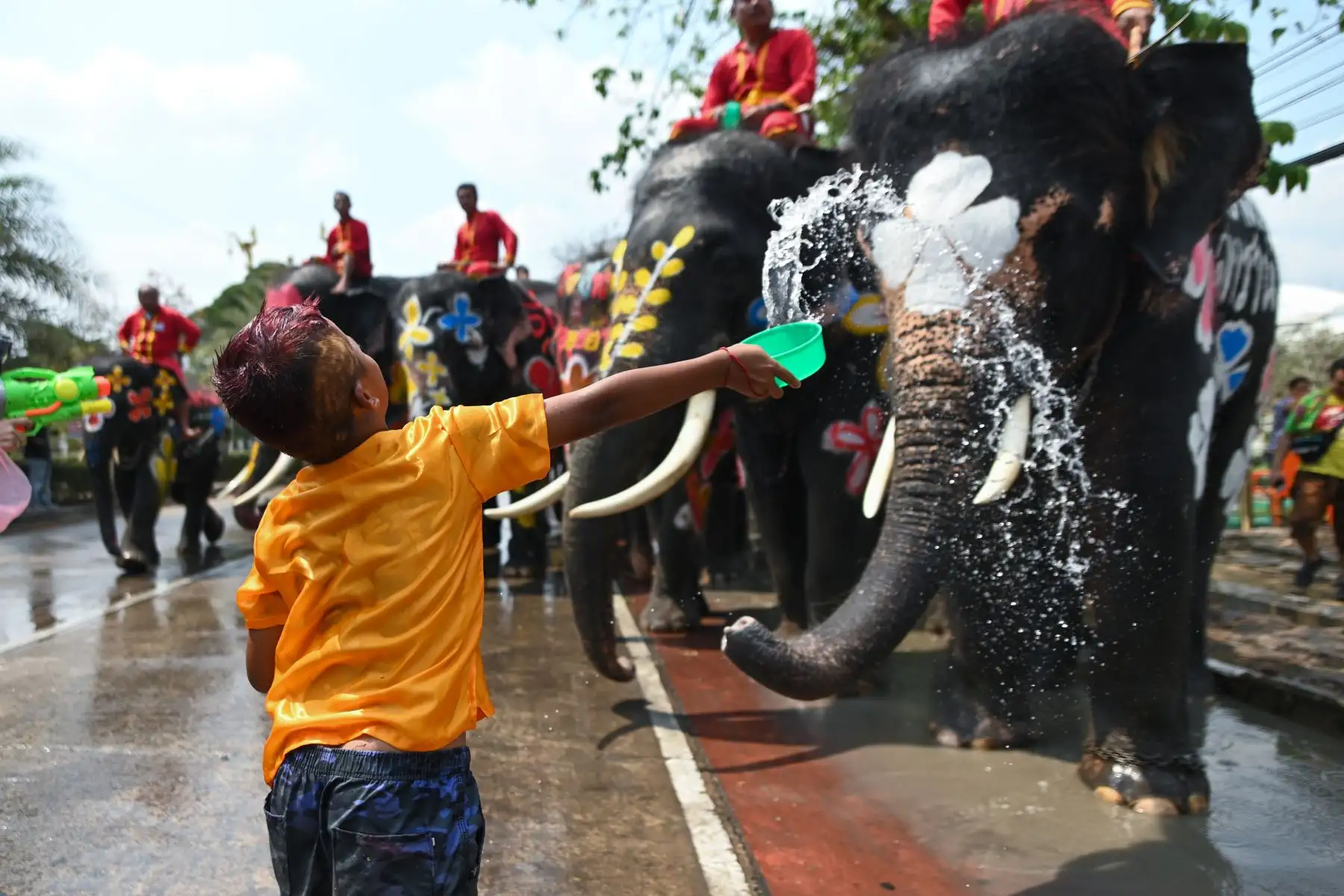 Elefantes y público se salpican agua unos a otros durante una ceremonia para celebrar el Año Nuevo Budista en Thailandia. Foto: AFP