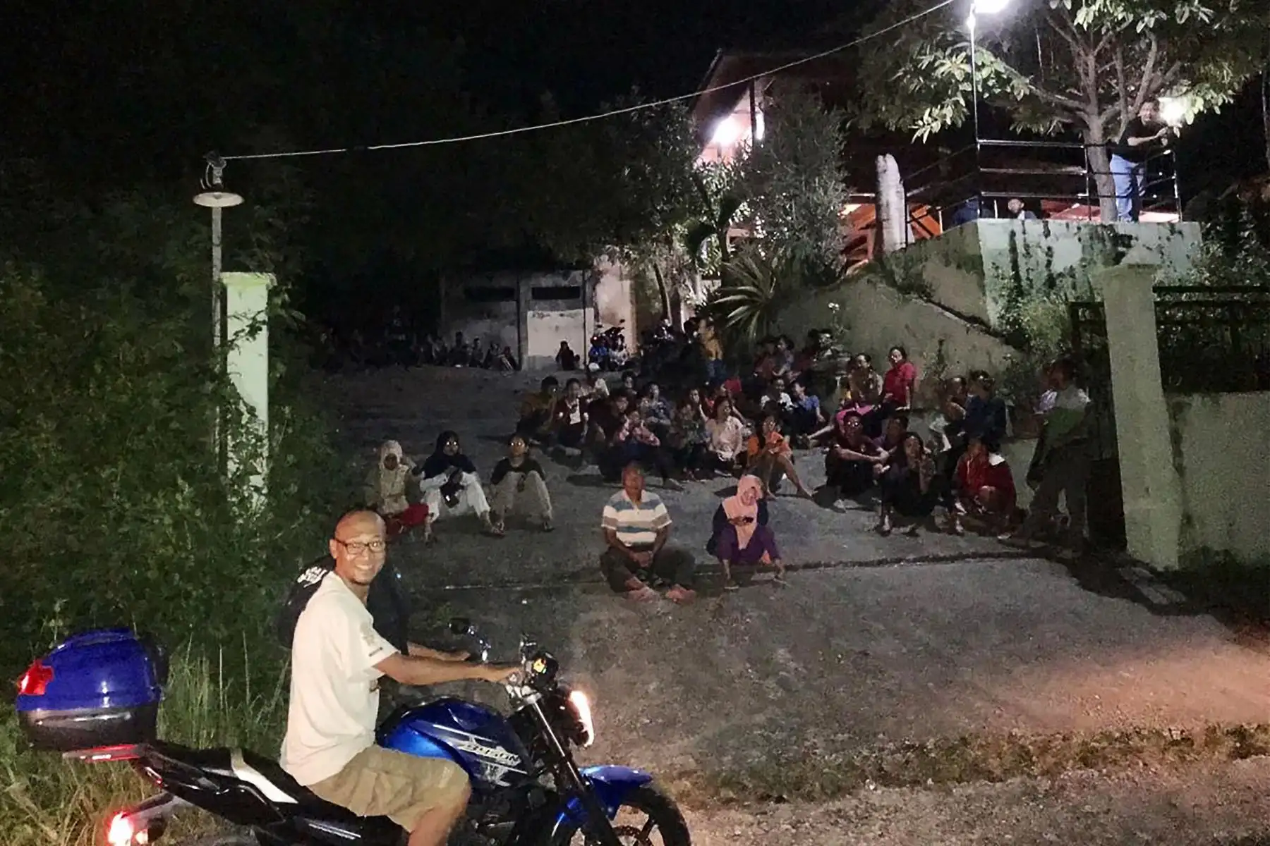 Fotografía tomada con un teléfono muestra a los residentes indonesios que se apresuran por un terreno más alto por temor a un tsunami después de un fuerte terremoto de magnitud 6,8 ​​sacudió Luwuk, en Indonesia. Foto: AFP