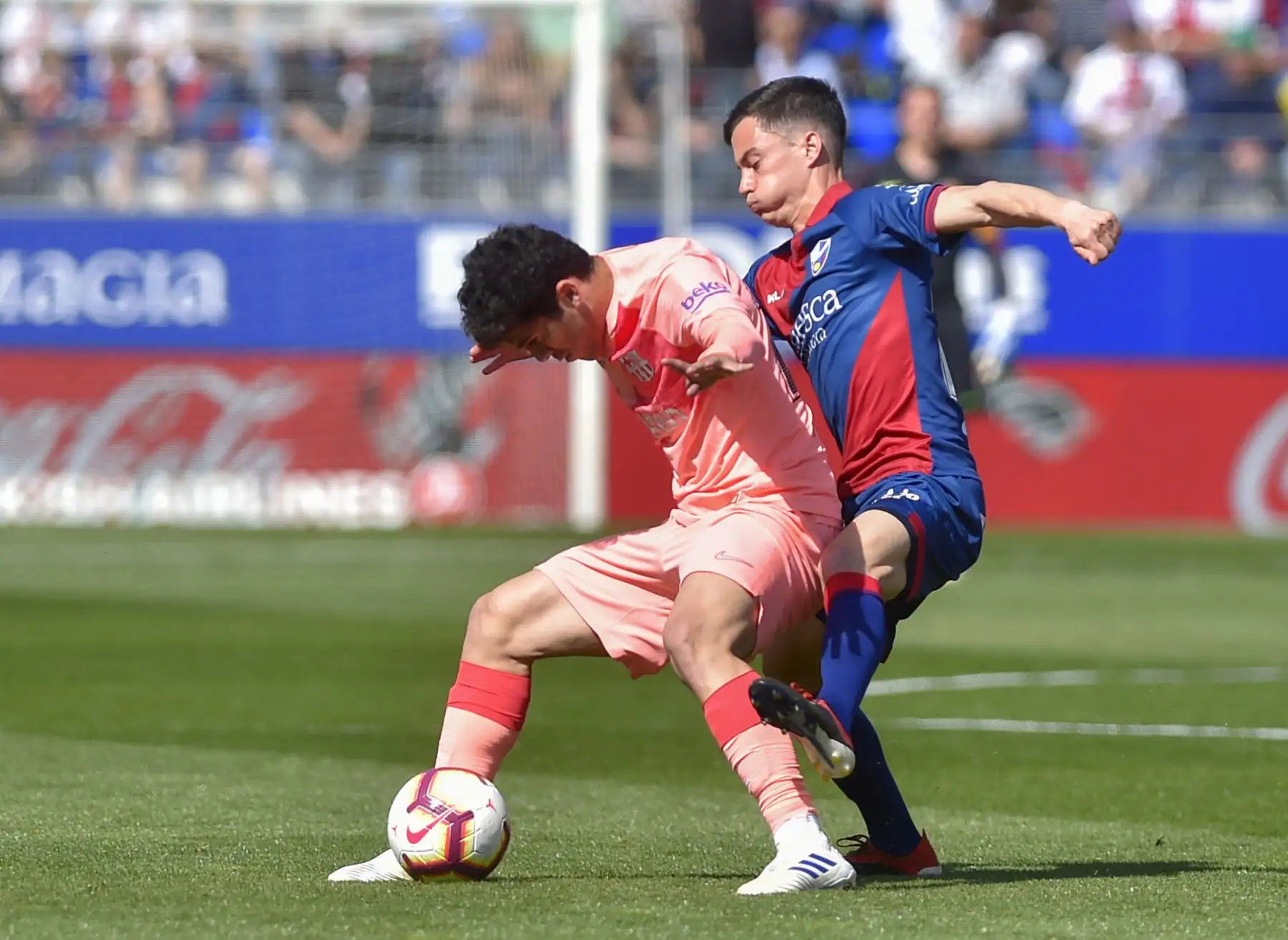 El mediocampista español del Barcelona Carles Alena (L) compite con el mediocampista venezolano Juanpi del SD Huesca durante el partido de fútbol de la liga española entre el SD Huesca y el FC Barcelona. Foto: AFP