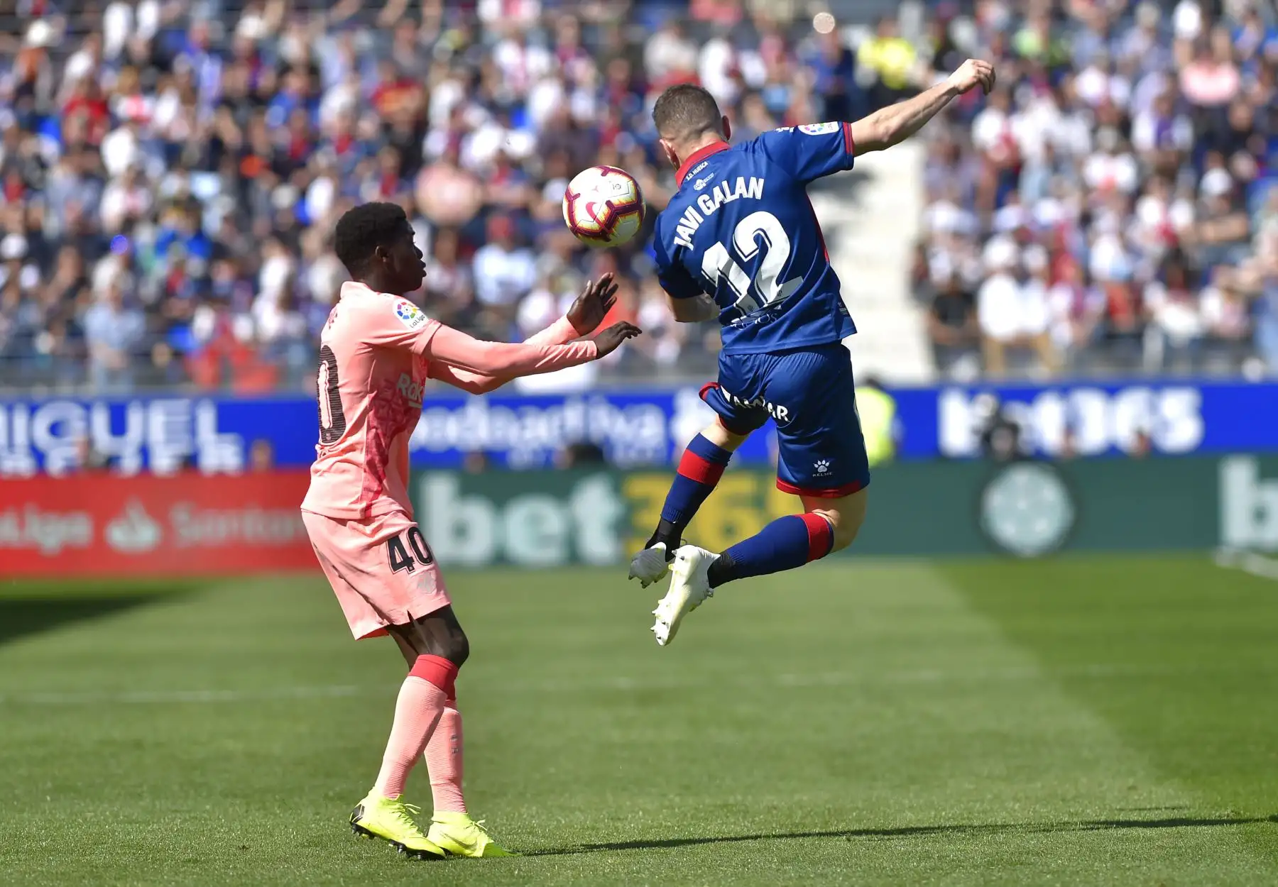 El delantero senegalés del Barcelona, Moussa Wague (L), compite con el mediocampista español del SD Huesca, Javi Galan, durante el partido de fútbol de la liga española entre el SD Huesca y el FC Barcelona.Foto: AFP