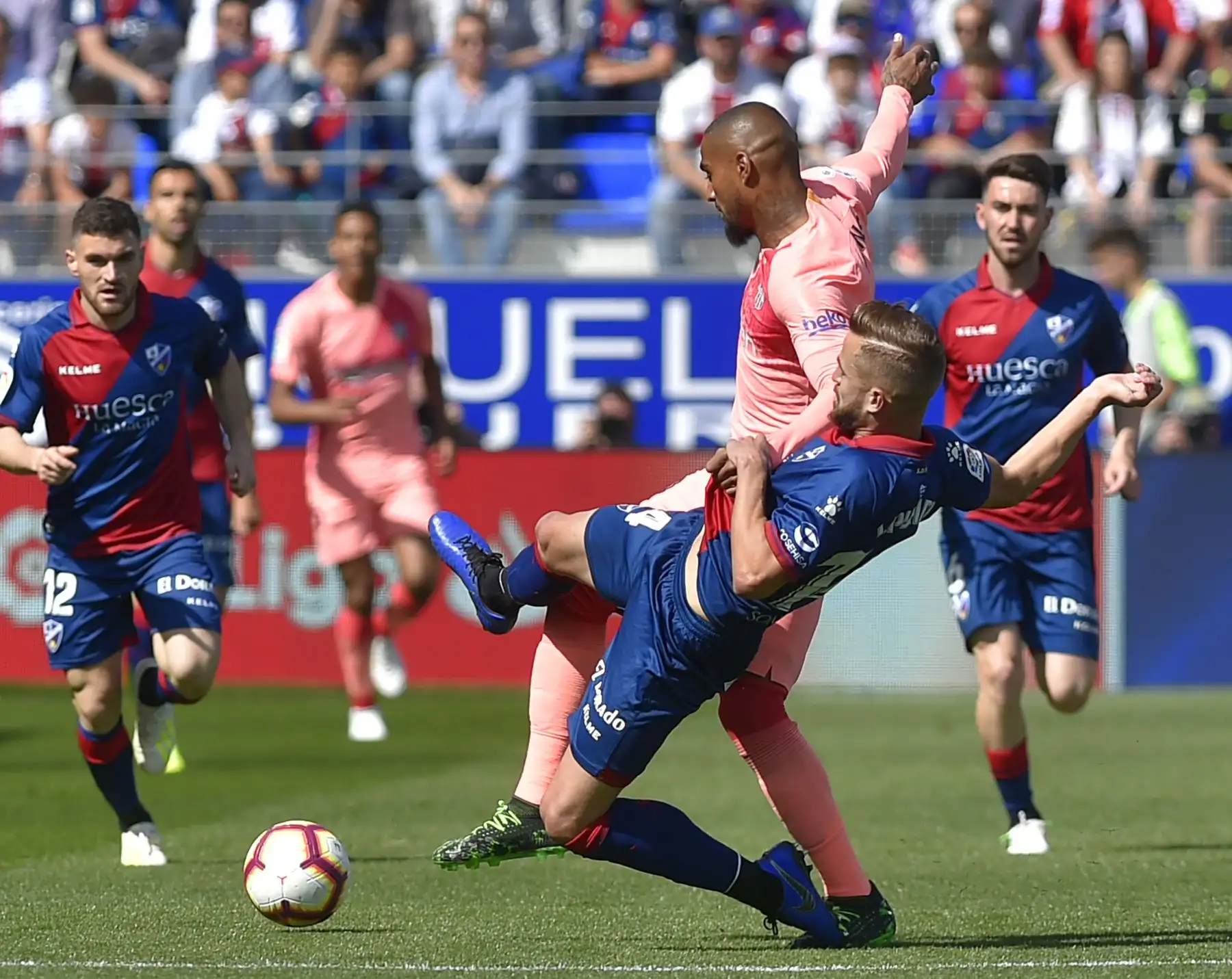 El delantero ghanés Kevin-Prince Boateng (arriba) compite con el defensor español Jorge Pulido, del SD Huesca, durante el partido de fútbol de la liga española entre el SD Huesca y el FC Barcelona.Foto:AFP