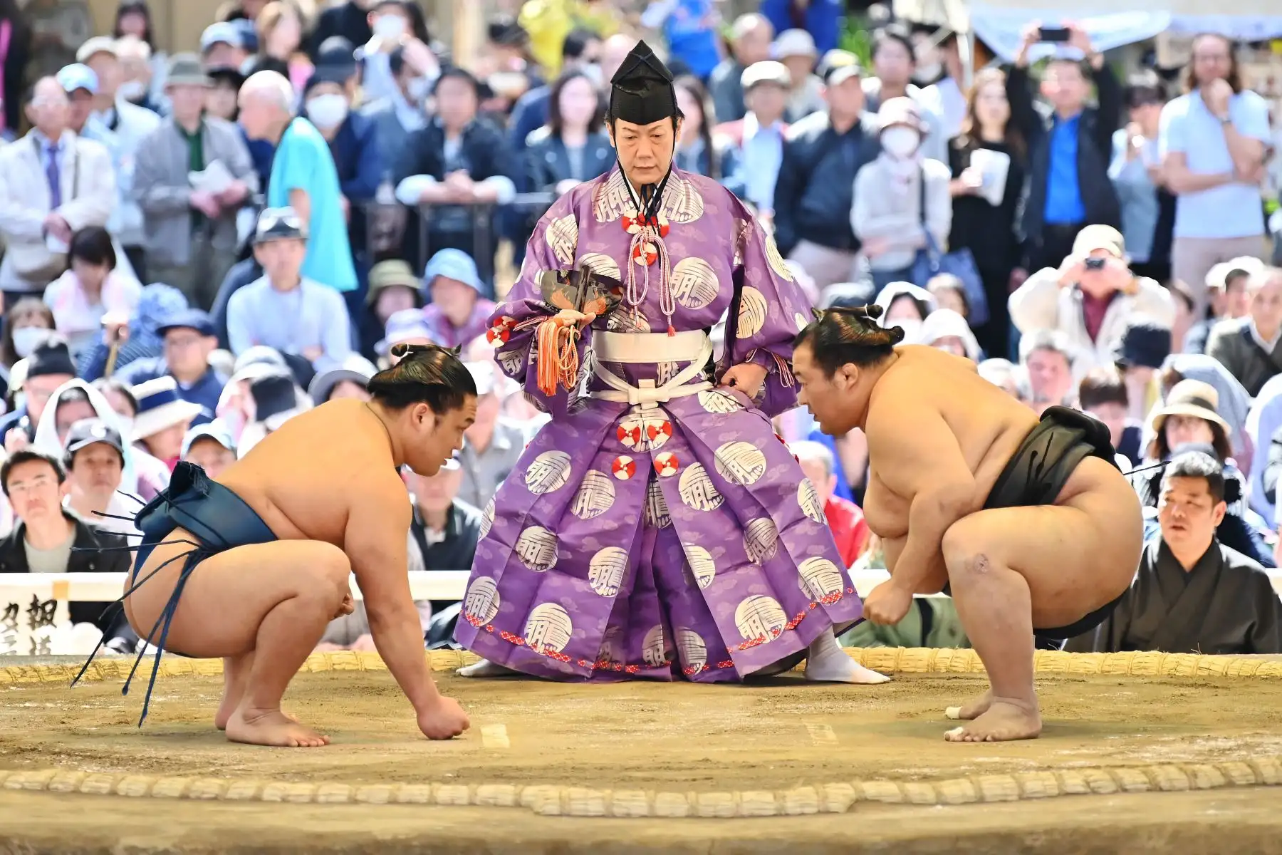 Los luchadores de sumo participan en una ceremonia tradicional de entrada al ring como parte de un "honozumo", una exhibición ceremonial de sumo, en los terrenos del santuario Yasukuni en Tokio. Foto: AFP