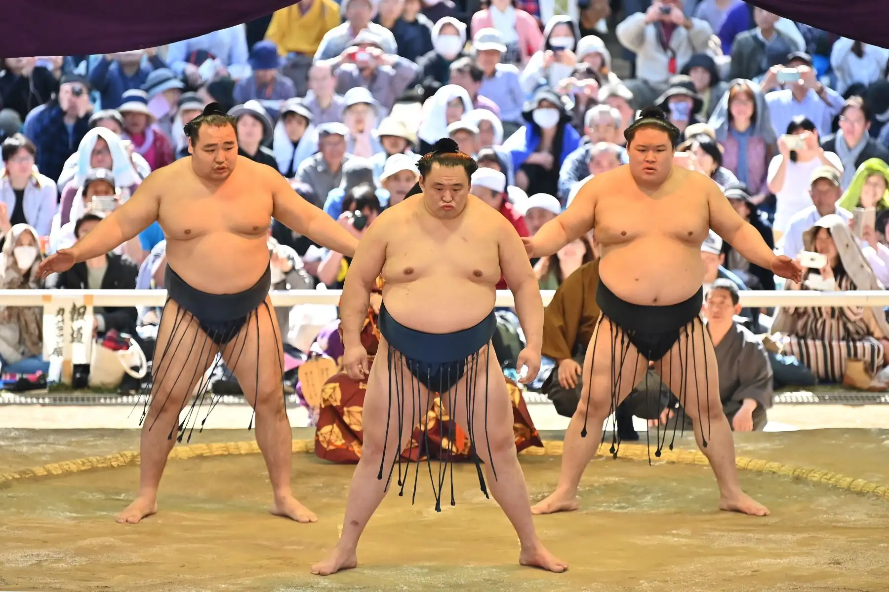 Los luchadores de sumo participan en una ceremonia tradicional de entrada al ring como parte de un "honozumo", una exhibición ceremonial de sumo, en los terrenos del santuario Yasukuni en Tokio. Foto: AFP