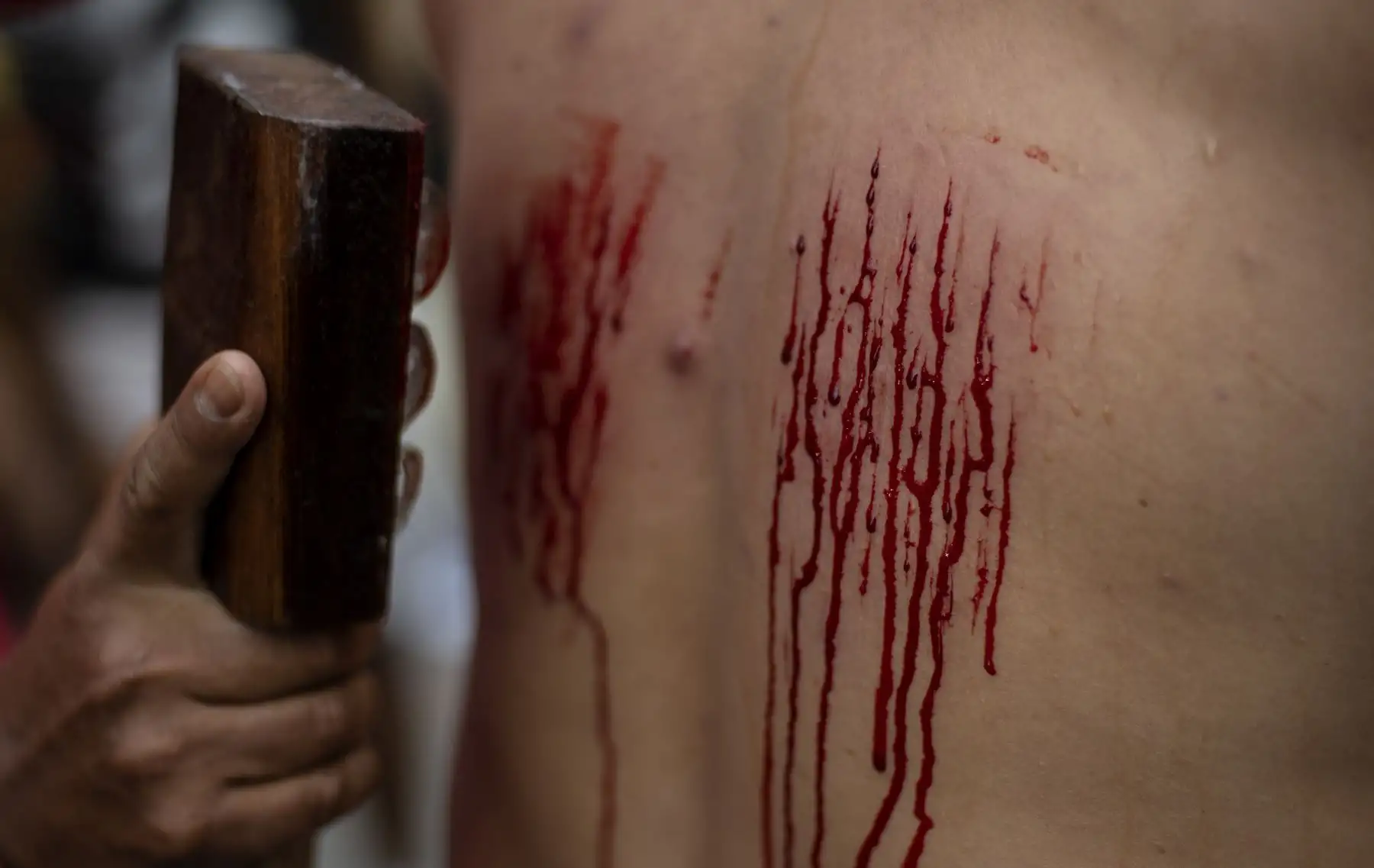 Un flagelante tiene su espalda herida como parte de su penitencia durante la recreación de la crucifixión de Jesucristo para el Viernes Santo en San Juan, Pampanga, al norte de Manila
Foto: AFP
