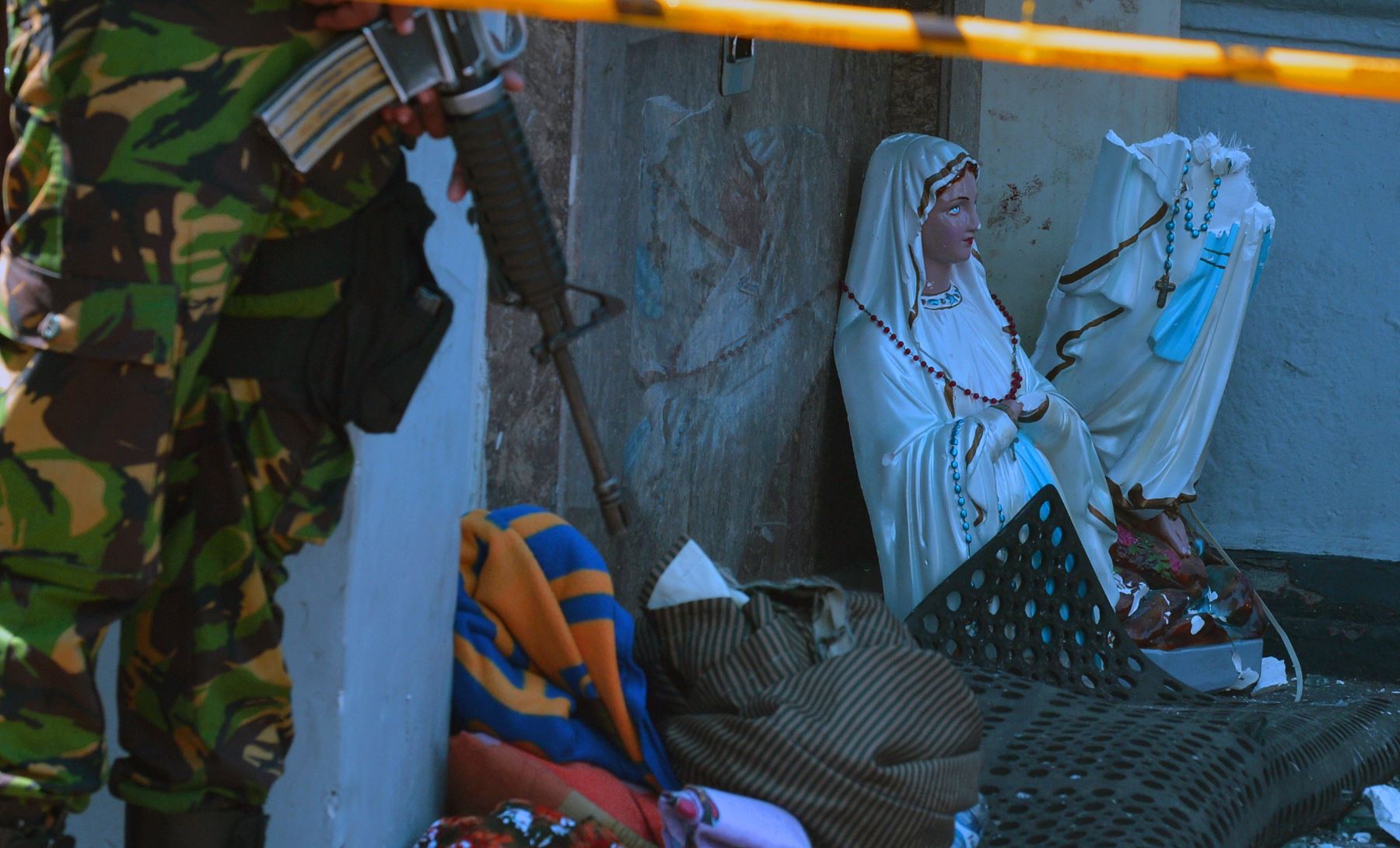 Un miembro de las fuerzas de seguridad de Sri Lanka se encuentra al lado de una estatua de la Virgen María rota en el Santuario de San Antonio después de un ataque con bomba en Kochchikade en Colombo - Sri Lanka.Foto:aAFP