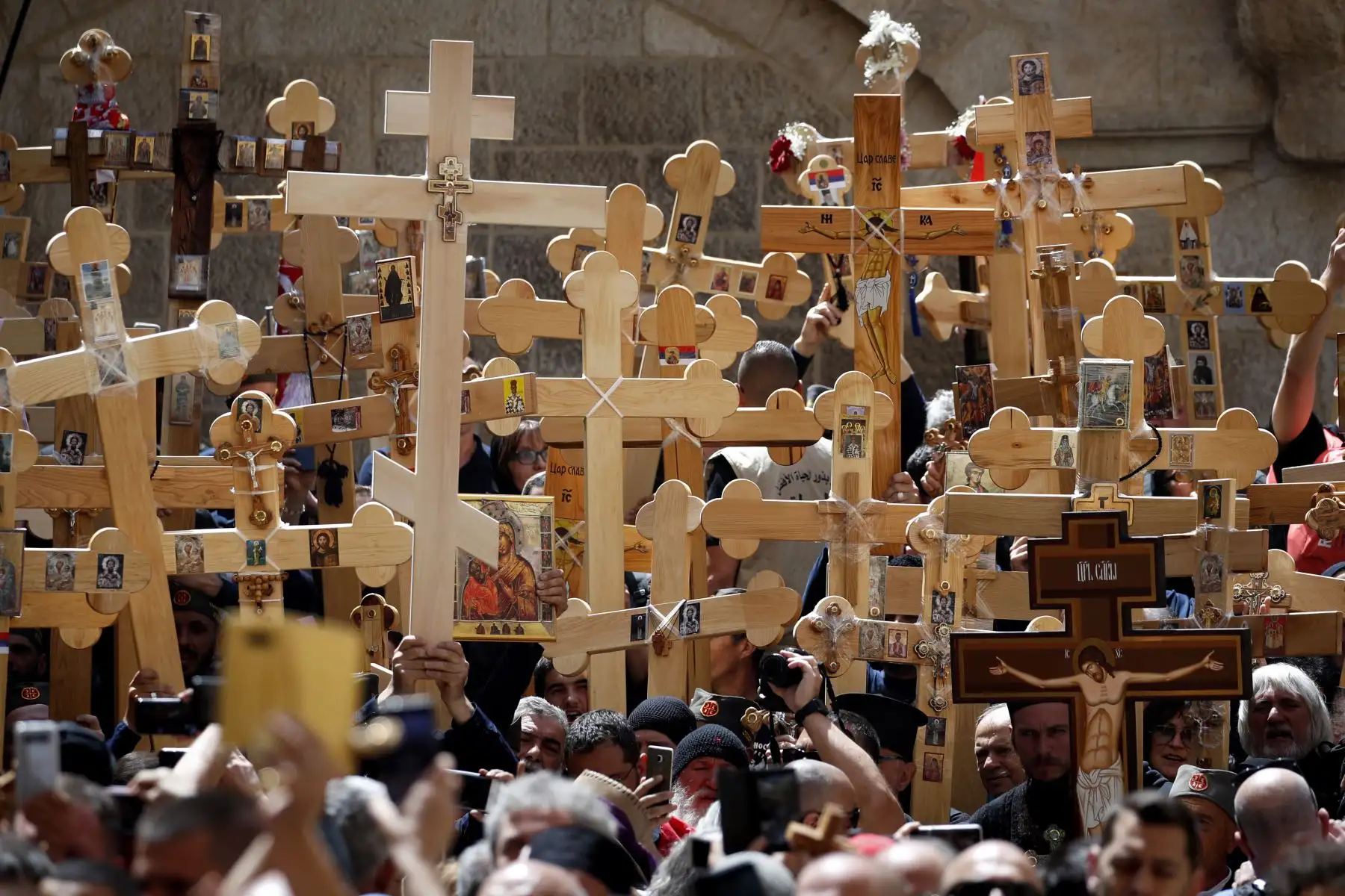 Cristianos ortodoxos se reúnen con cruces de madera frente a la Iglesia del Santo Sepulcro mientras celebran el Viernes Santo 
en Jerusalén. Foto: AFP