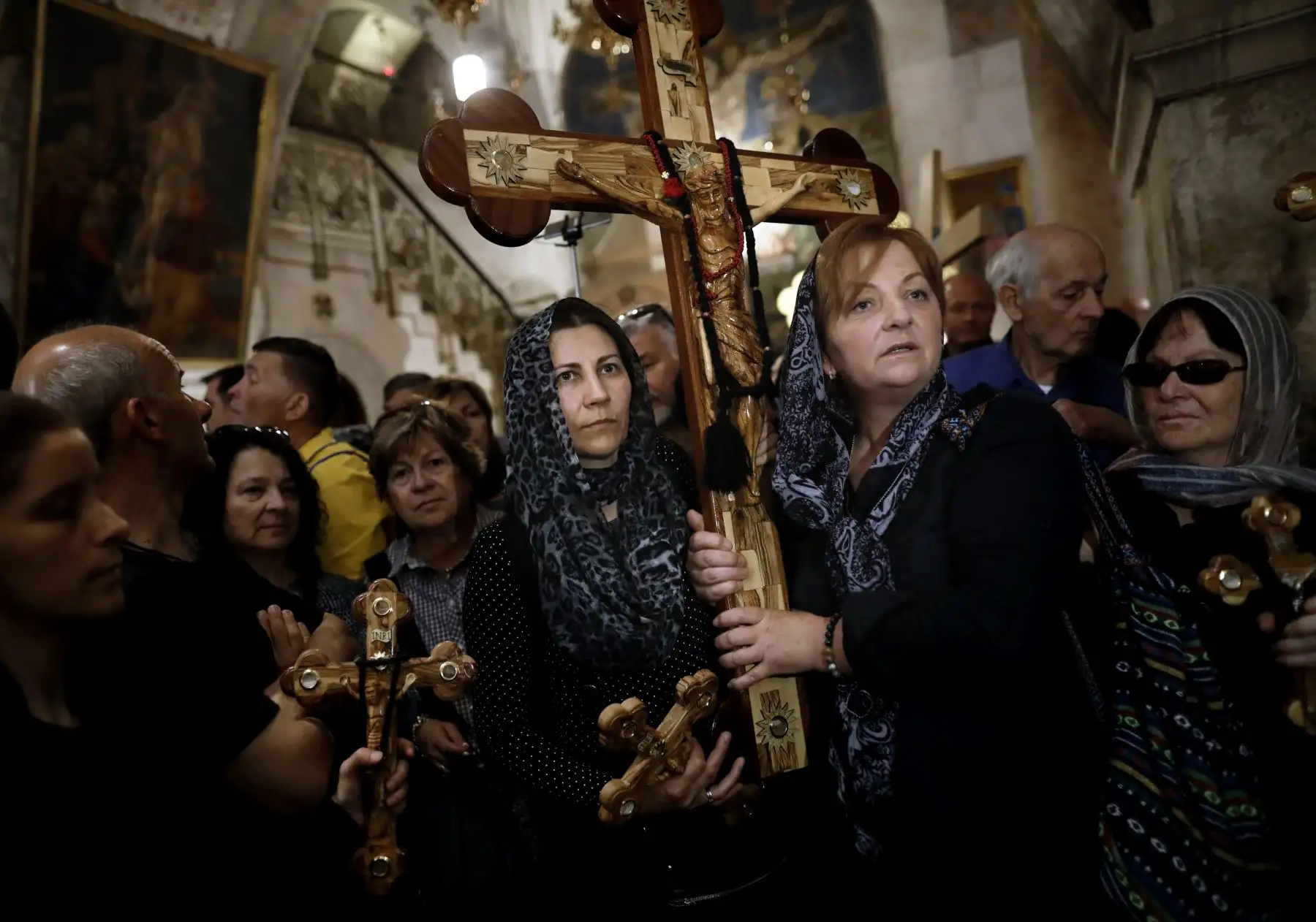 Cristianos ortodoxos se reúnen con cruces de madera frente a la Iglesia del Santo Sepulcro mientras celebran el Viernes Santo en Jerusalén. Foto: AFP