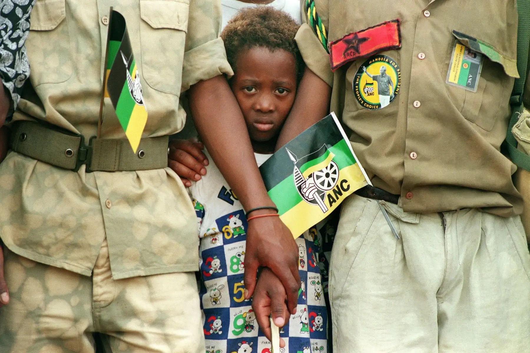 Una niña intenta ver al presidente Nelson Mandela, en una granja de entrenamiento en Boskop, en el oeste de Transvaal, el 31 de enero de 1994. Foto: AFP