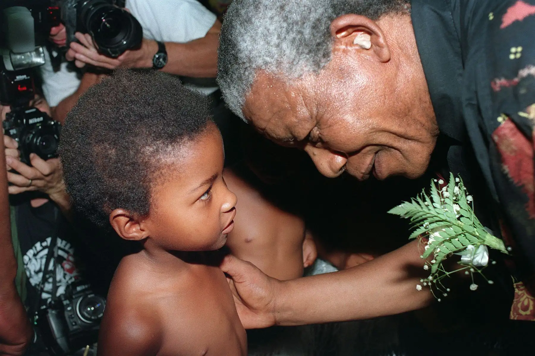 El líder del Congreso Nacional Africano (ANC), Nelson Mandela, escucha a un niño el 31 de enero de 1994 en Boskop, Western Transvaal. Foto: AFP