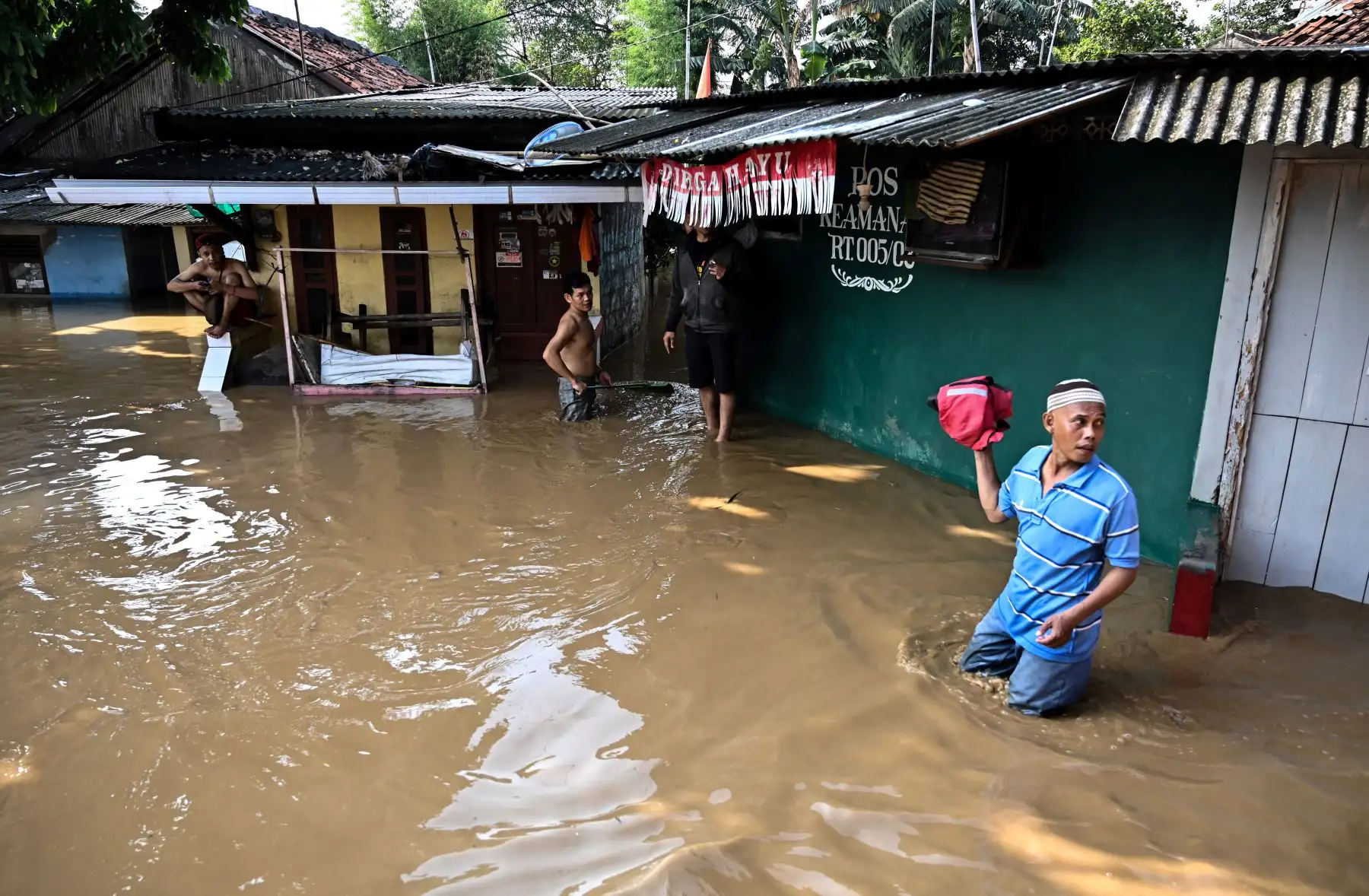 Residentes caminan a través de las inundaciones en Yakarta, luego de que varias áreas se vieron afectadas por fuertes lluvias. Foto: AFP