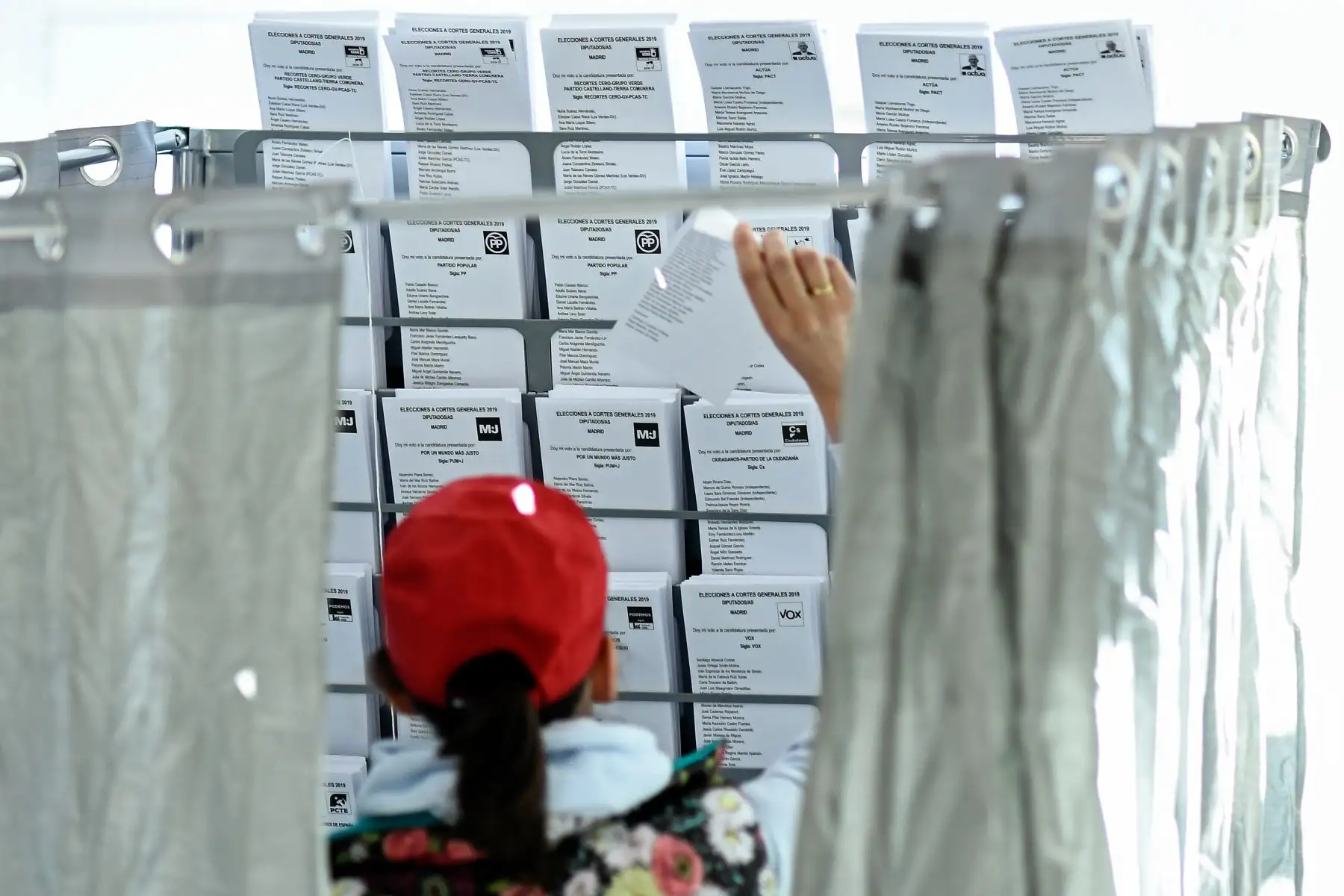 Un votante elige las boletas electorales dentro de una casilla electoral en una mesa electoral en Madrid durante las elecciones generales en España.
Foto:AFP