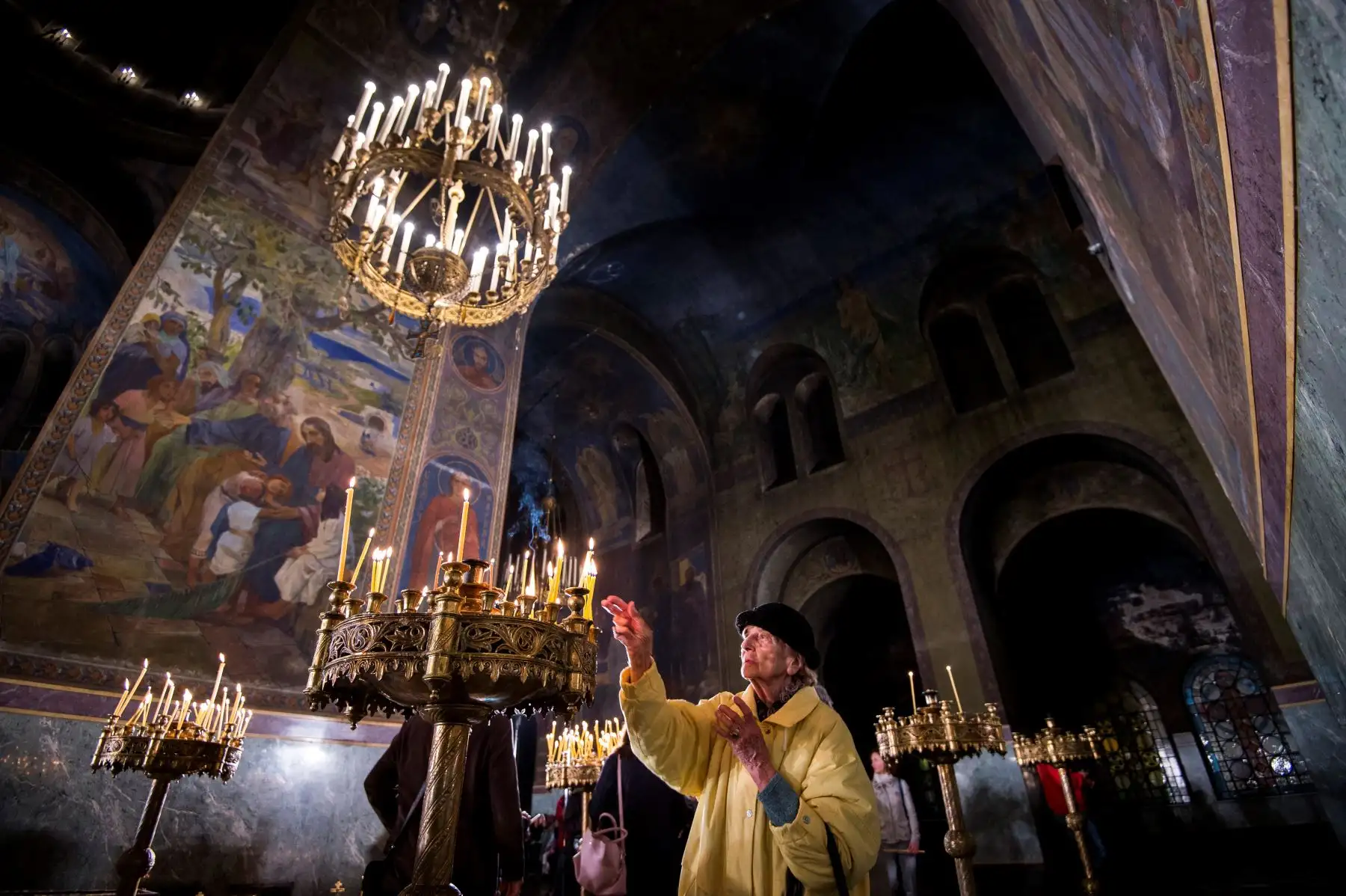 Un creyente cristiano ortodoxo enciende una vela durante una misa de Pascua en la Catedral de Bulgaria. Foto: AFP